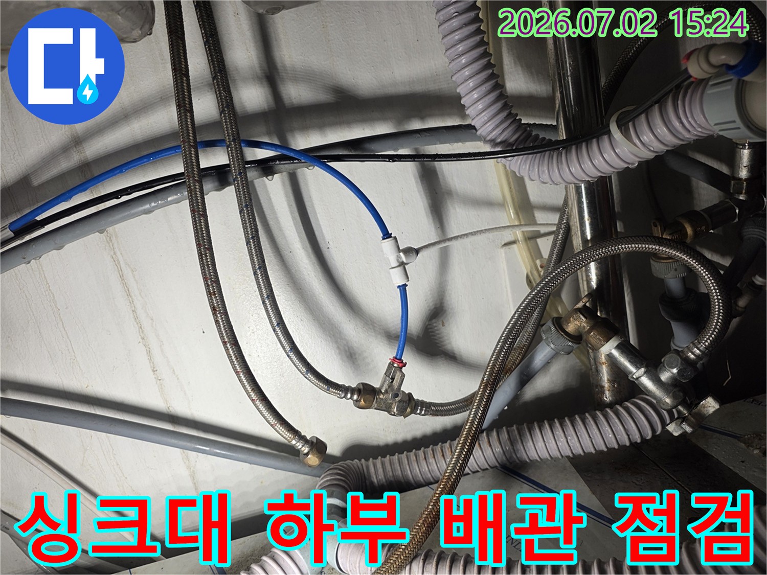 노후된 싱크대 급수 호스와 연결 부위의 파손 상태를 촬영한 모습