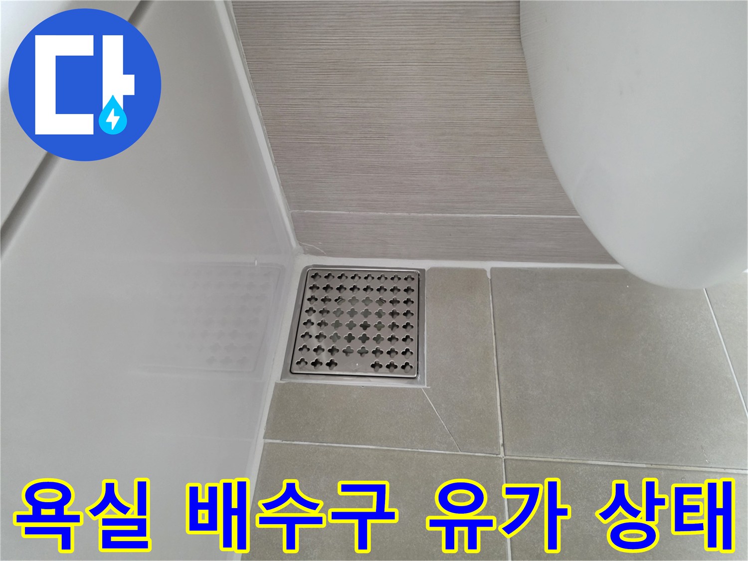 스테인리스 재질의 배수구 덮개와 주변 타일 모습입니다.