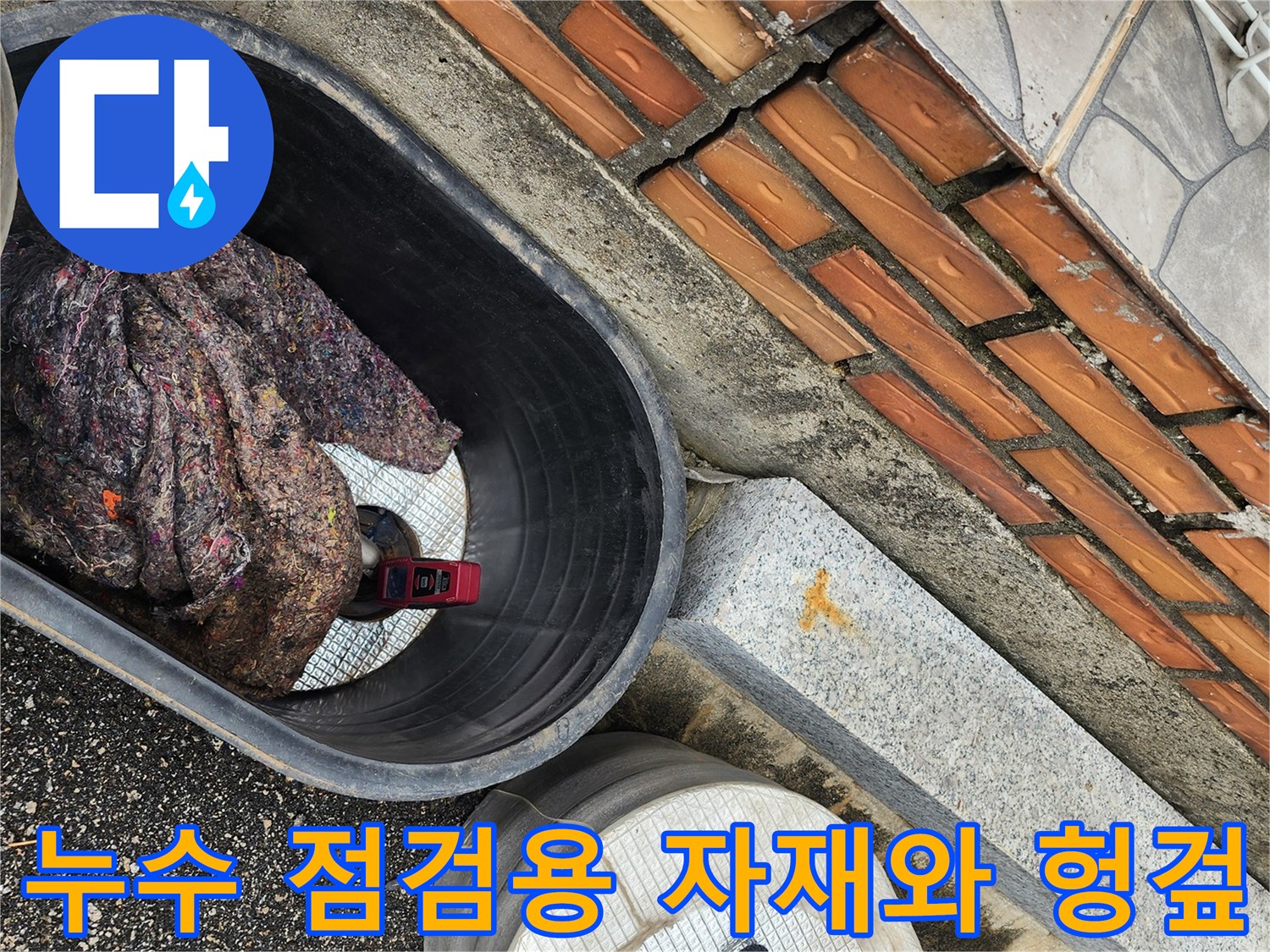 파주 현장 작업-벽돌 구조물 옆에 놓인 누수 보수용 자재들