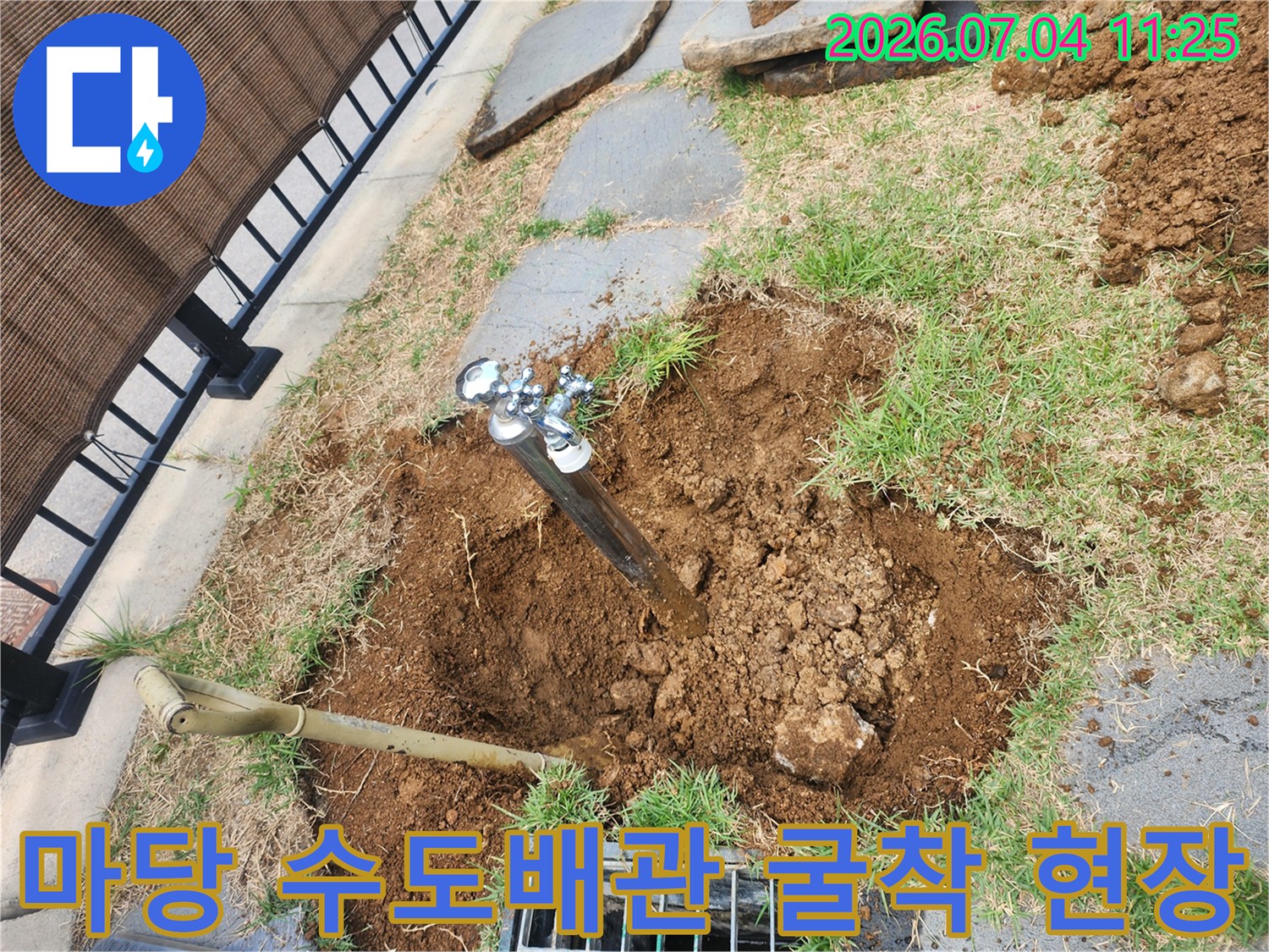 마당의 흙을 파헤쳐 노출된 수도 배관과 작업용 삽