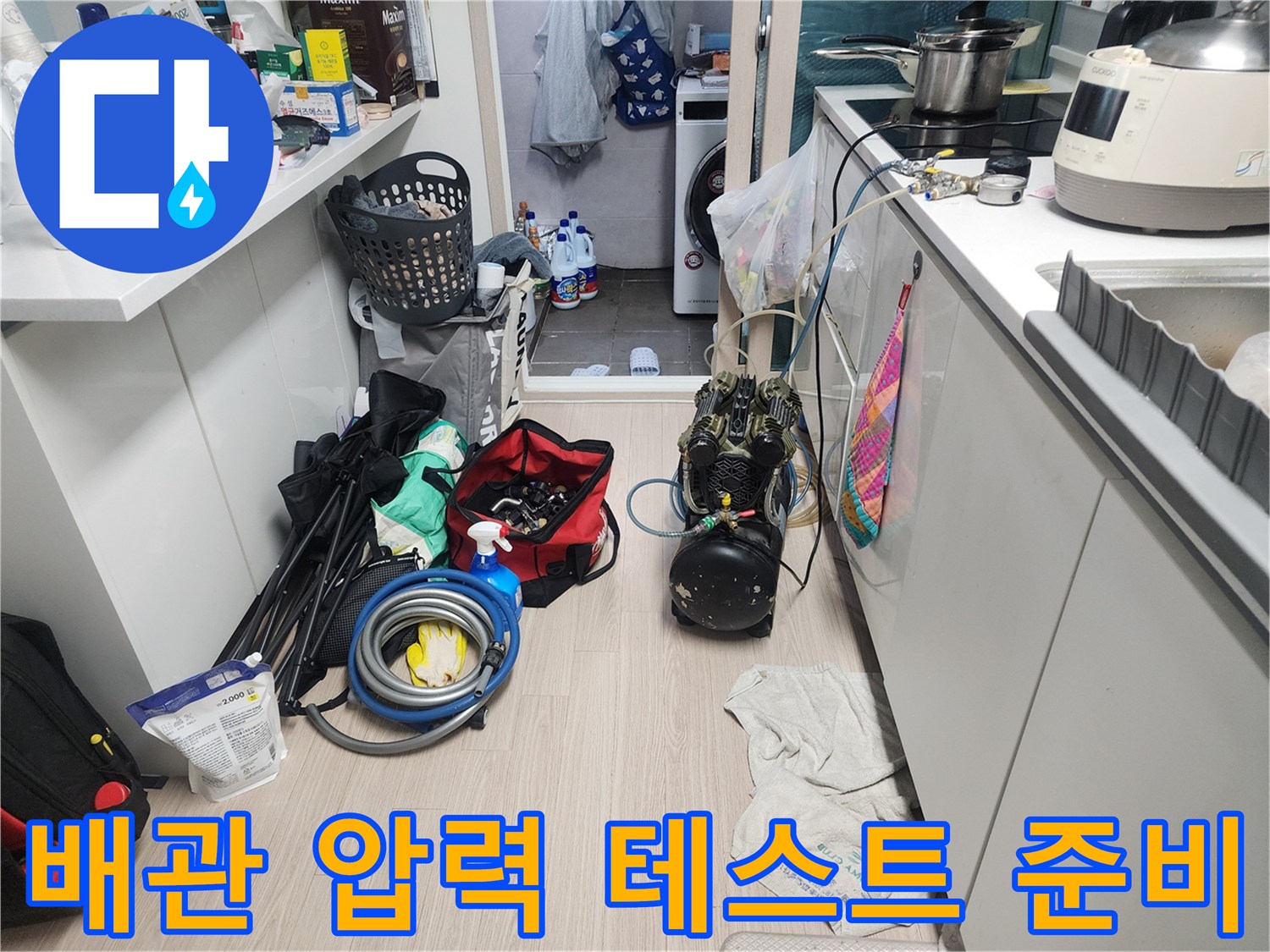 싱크대 하부 작업 공간에 놓인 배관 점검용 펌프와 호스
