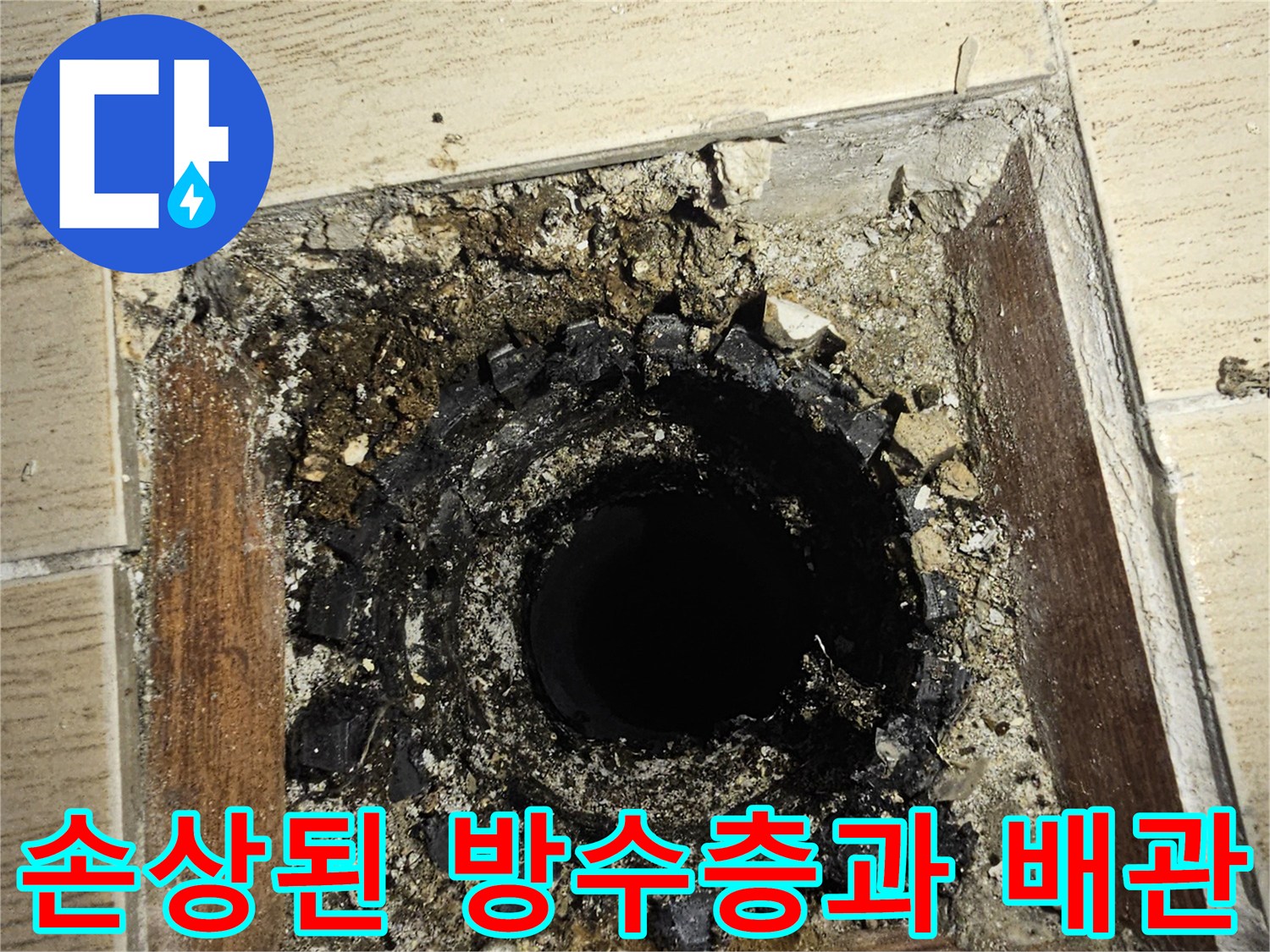 배관 주변의 깨진 타일과 노출된 흙 및 이물질