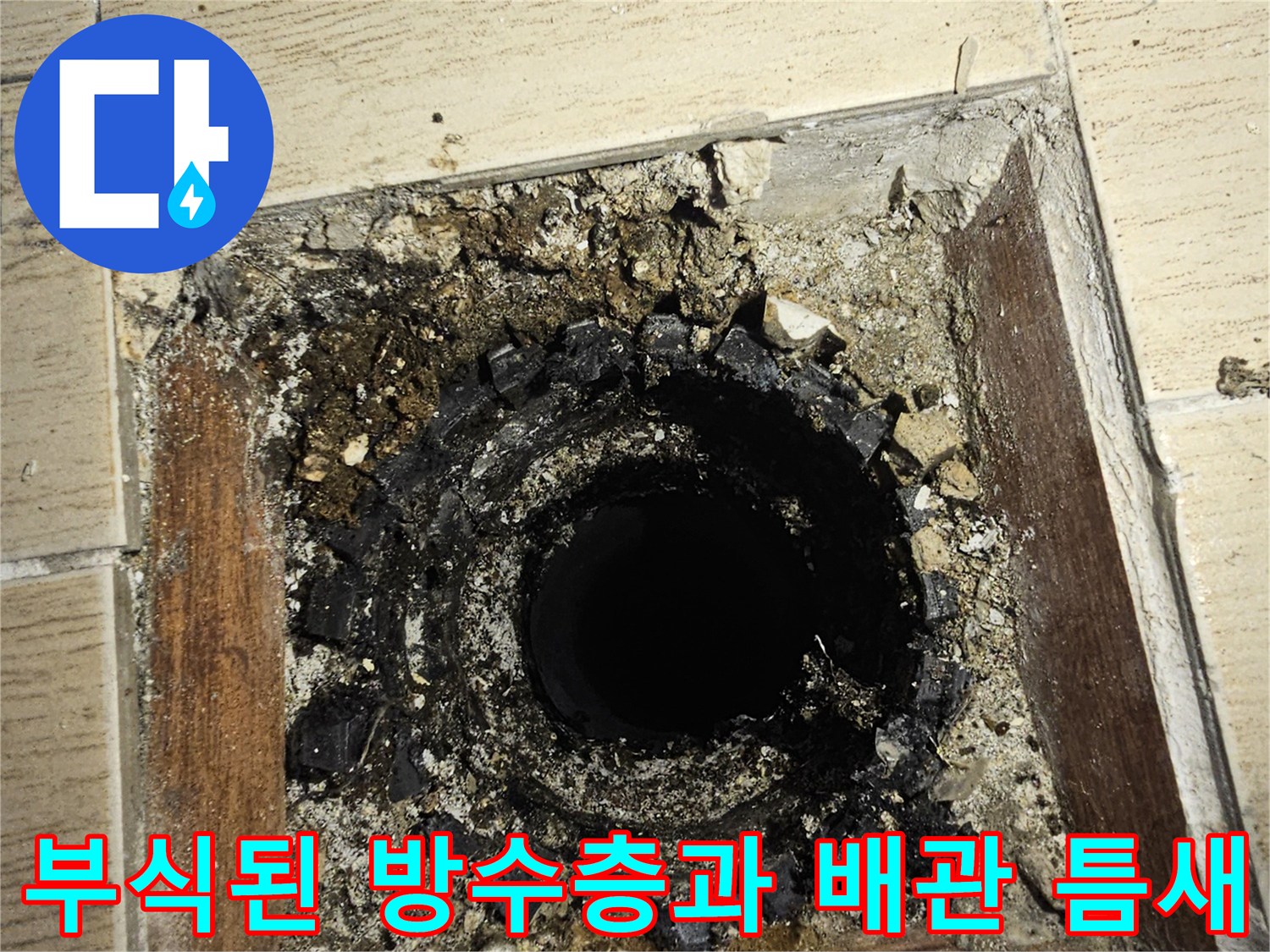 배관 주위의 깨진 타일과 이물질이 가득한 누수 지점 사진