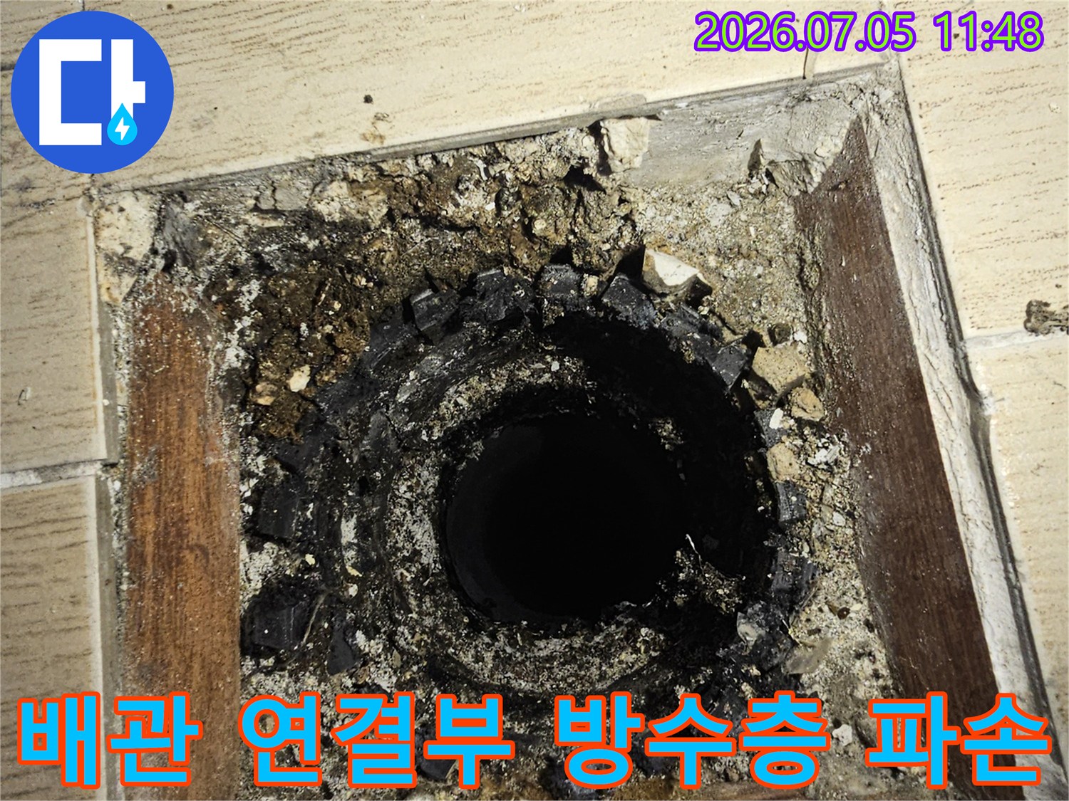 우수관과 배관이 만나는 지점의 노후된 마감재와 균열 부위