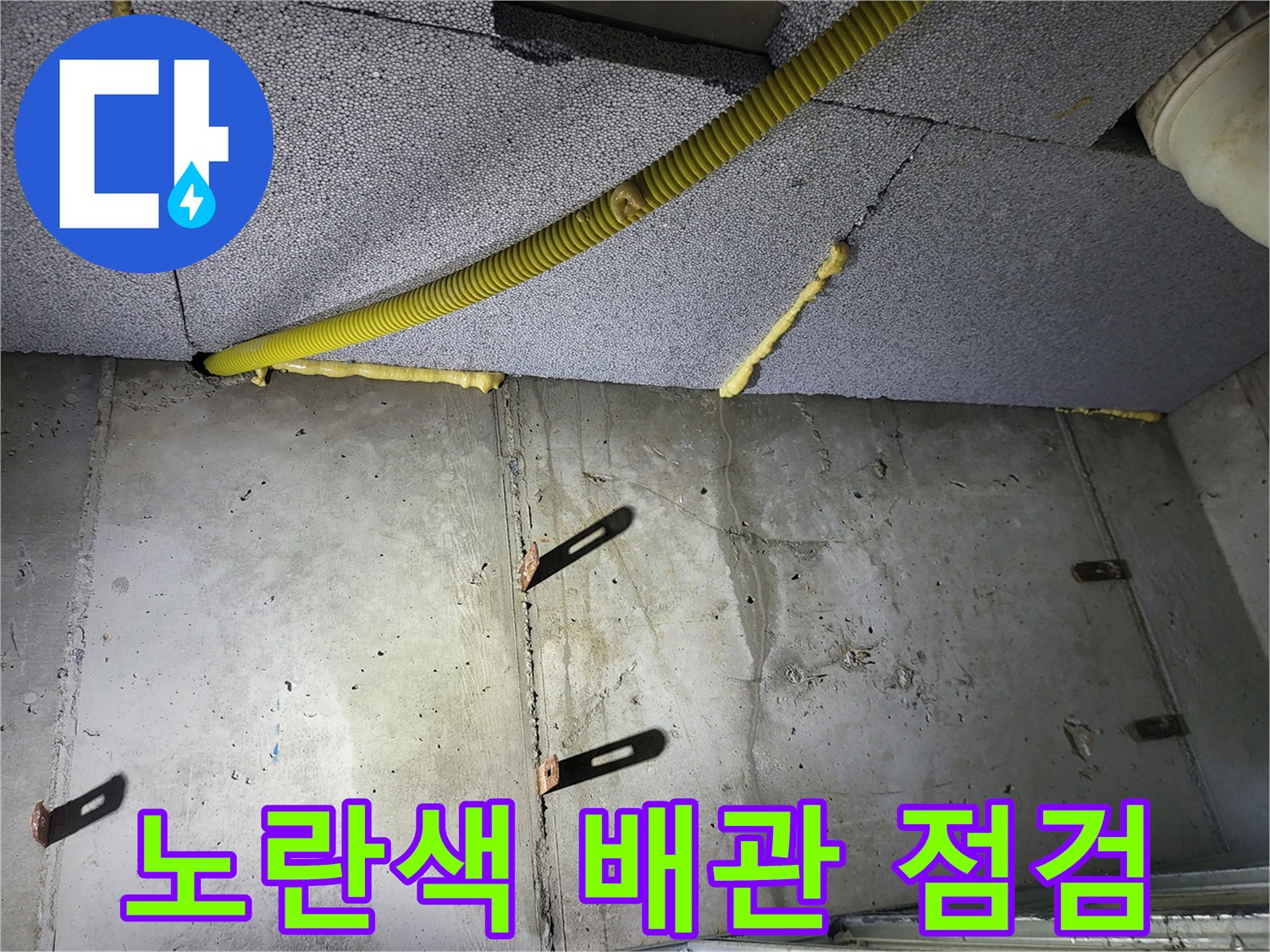 천장 마감재와 노란색 배관-콘크리트 벽면 구조