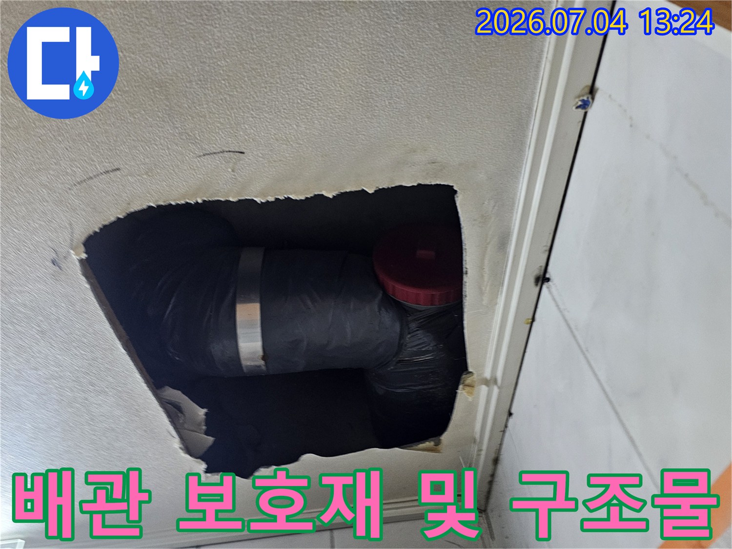 화장실 천장 내부에 설치된 검은색 배관과 연결부 확인용 사진