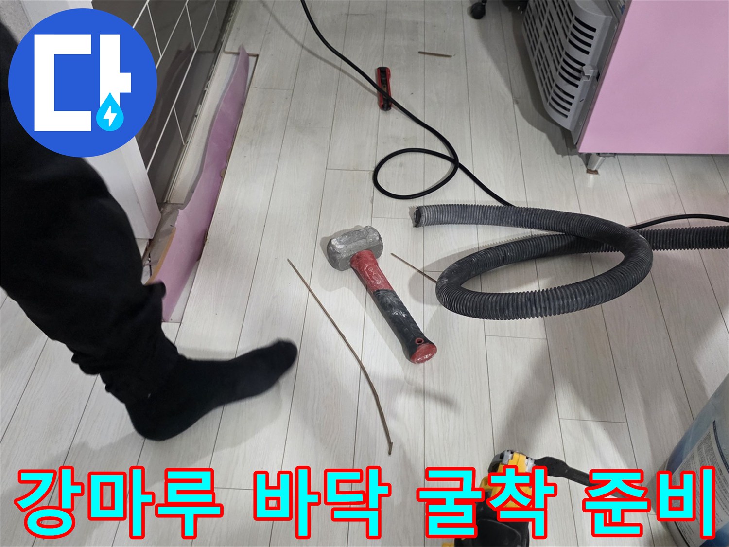 공사 중인 강마루 바닥과 작업용 망치 모습