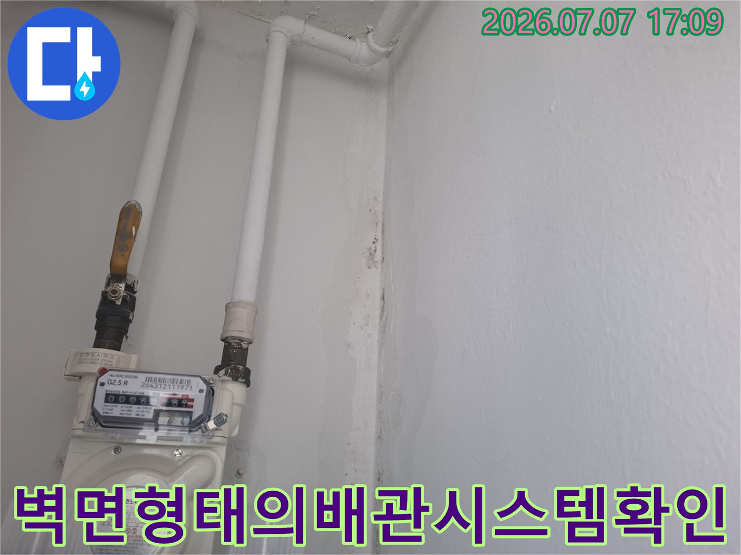 베란다 벽면에 고정된 배관과 계량기 세부 점검