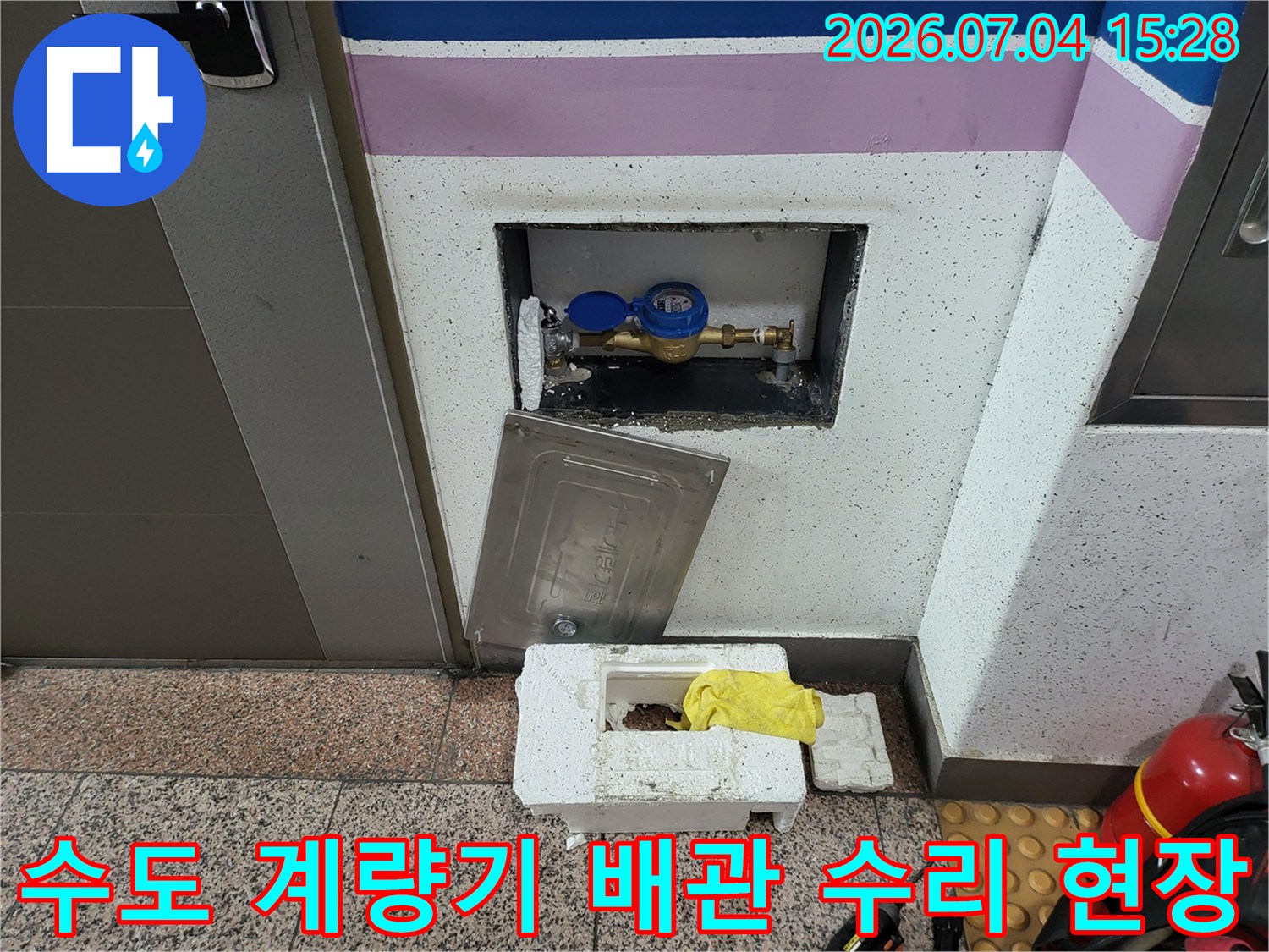 복도 계량기함 내부의 수도 배관 보수 작업