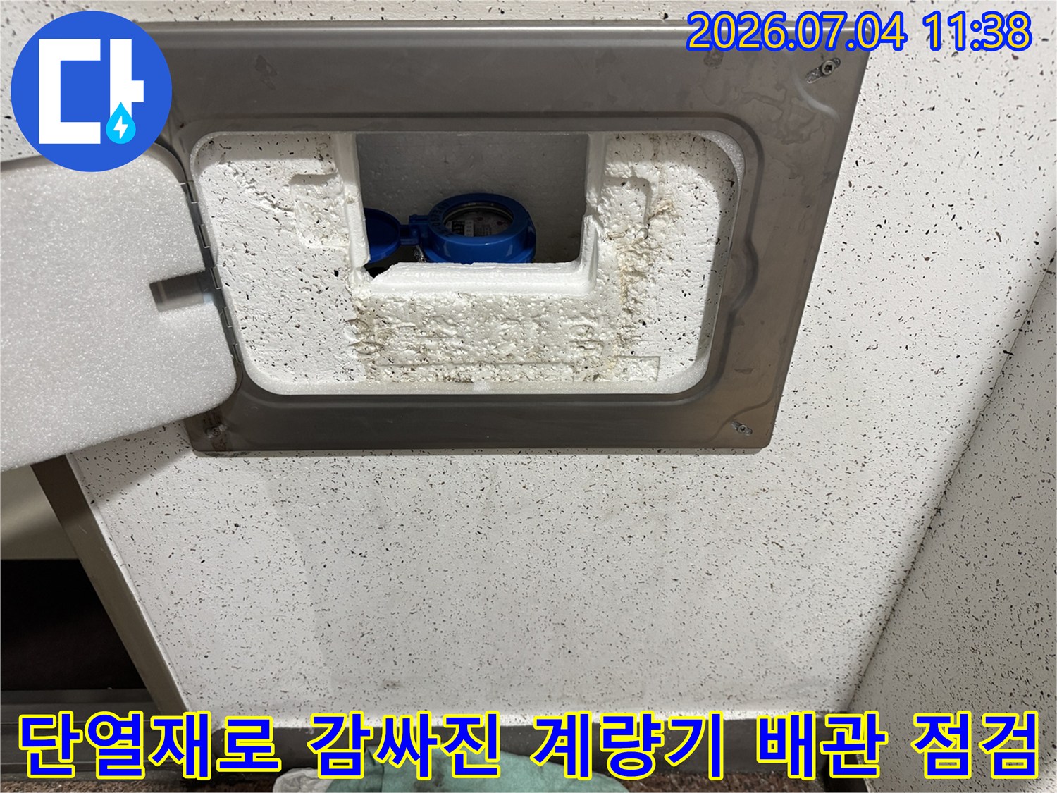흰색 단열재와 파란색 배관이 노출된 수도계량기함 내부 모습