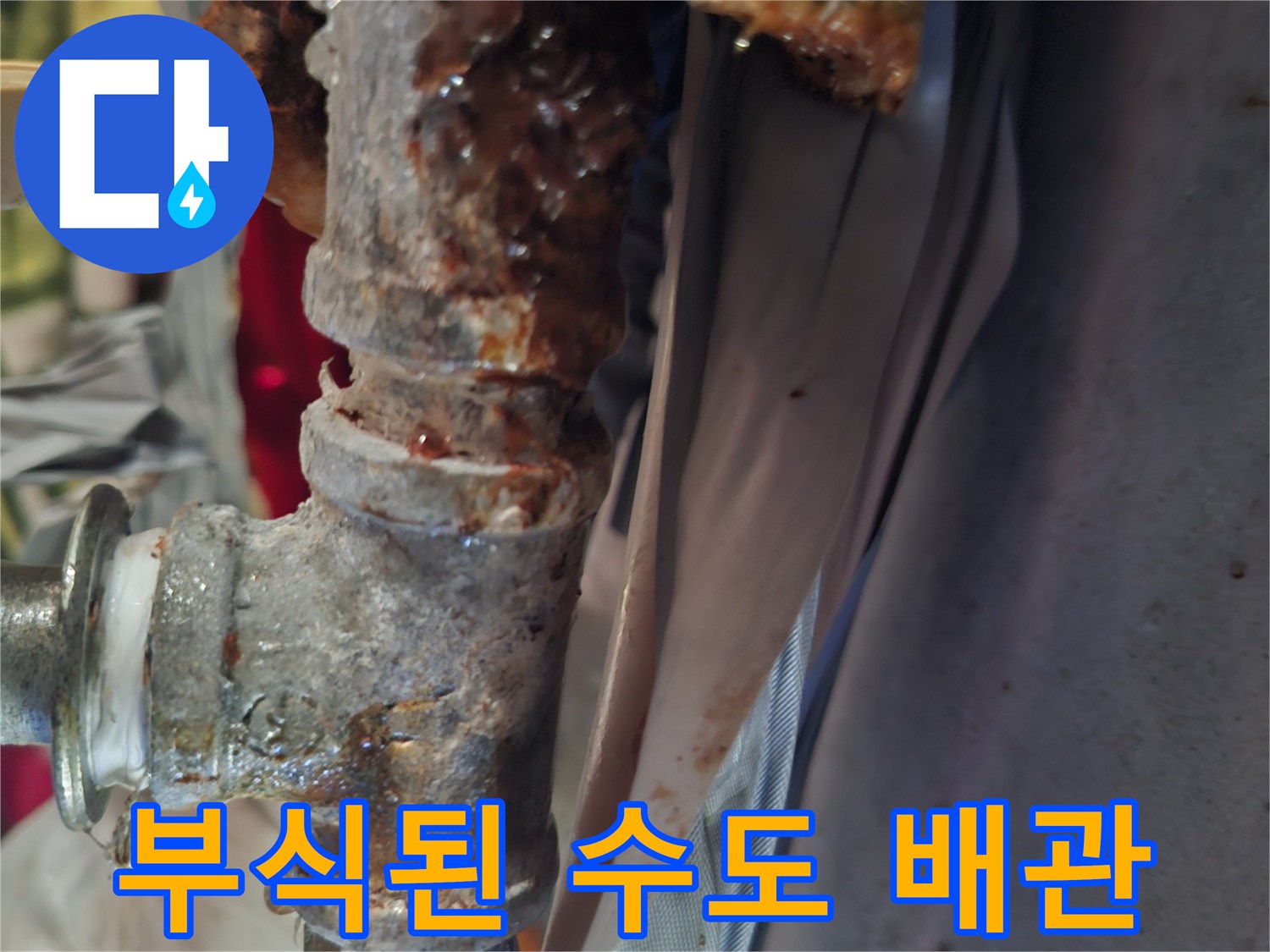 붉은색 부식이 심하게 진행된 금속 배관 연결부
