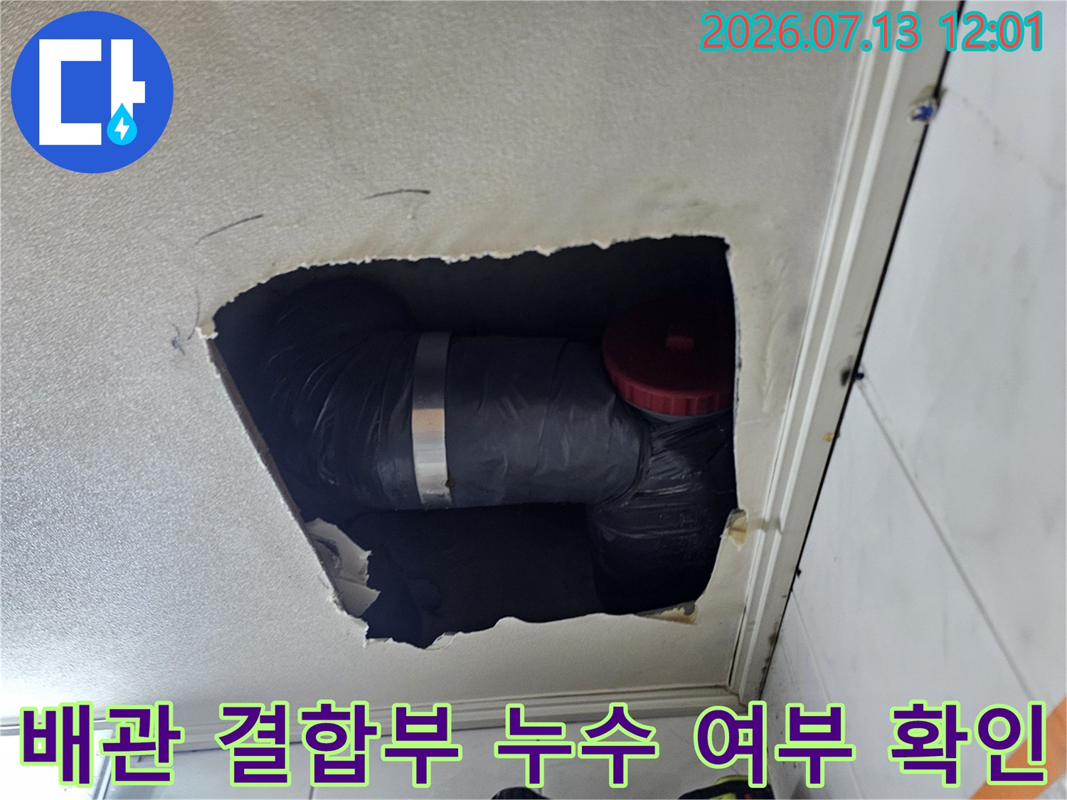 천장 내부에 노출된 배관과 붉은색 마감 부분 점검 장면