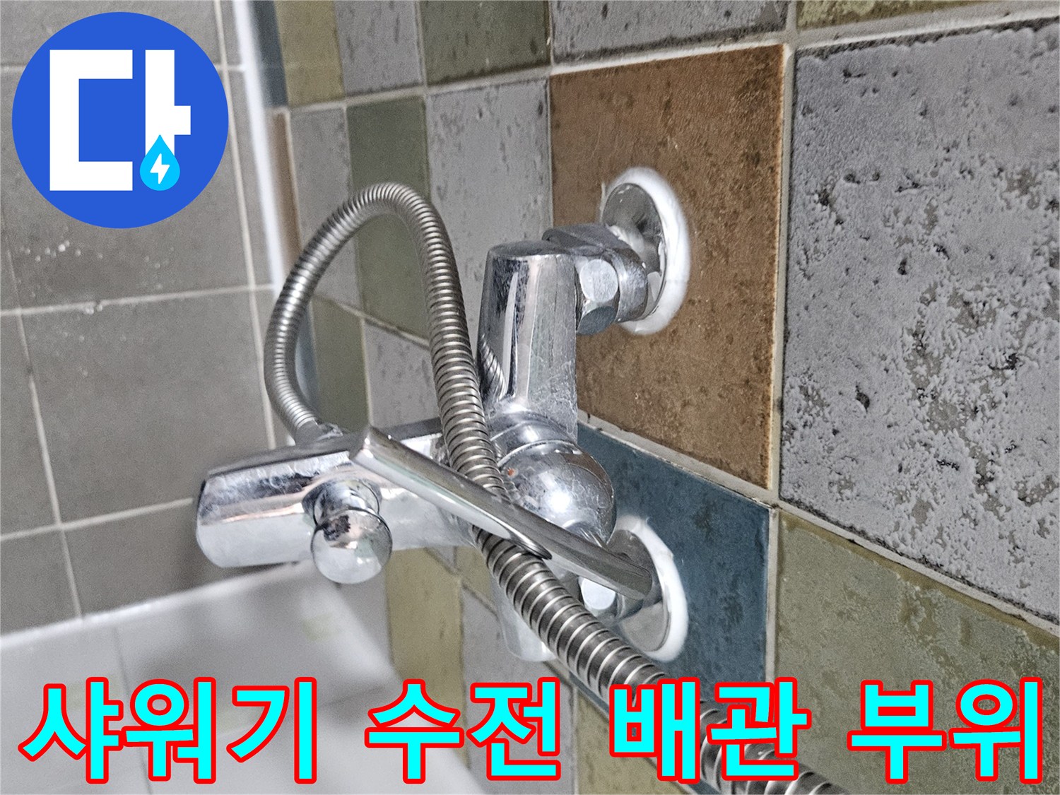 욕실 벽면 타일과 샤워기 수전 연결 부위를 근접 촬영한 모습입니다.