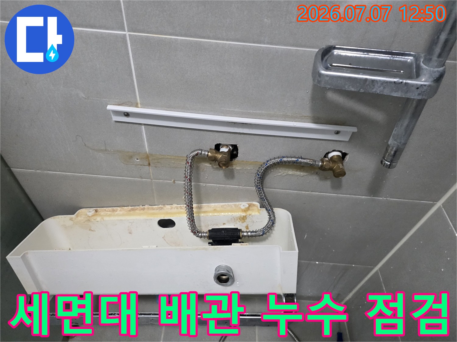 세면대 하부의 노출된 수도 배관과 밸브 부위 점검 모습