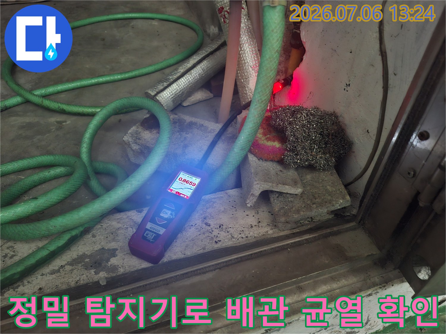 특수 가스 탐지기를 사용하여 벽면 근처 배관의 파손 부위를 식별하는 장면