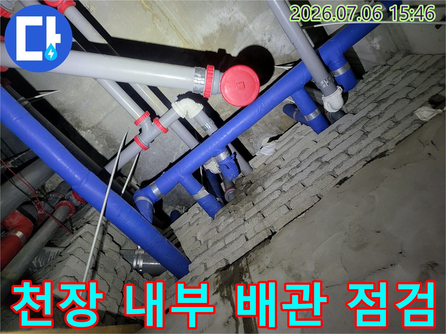 복잡하게 얽힌 천장 내 파란색과 회색 배관들 점검 모습