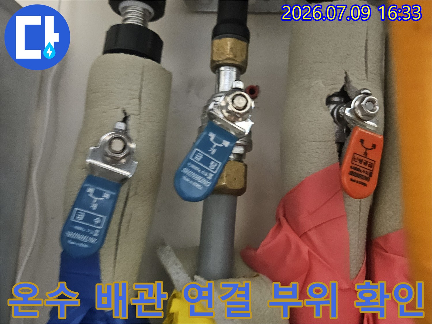 보일러룸 내의 온수 및 냉수 공급 라인과 밸브 부속 점검 장면