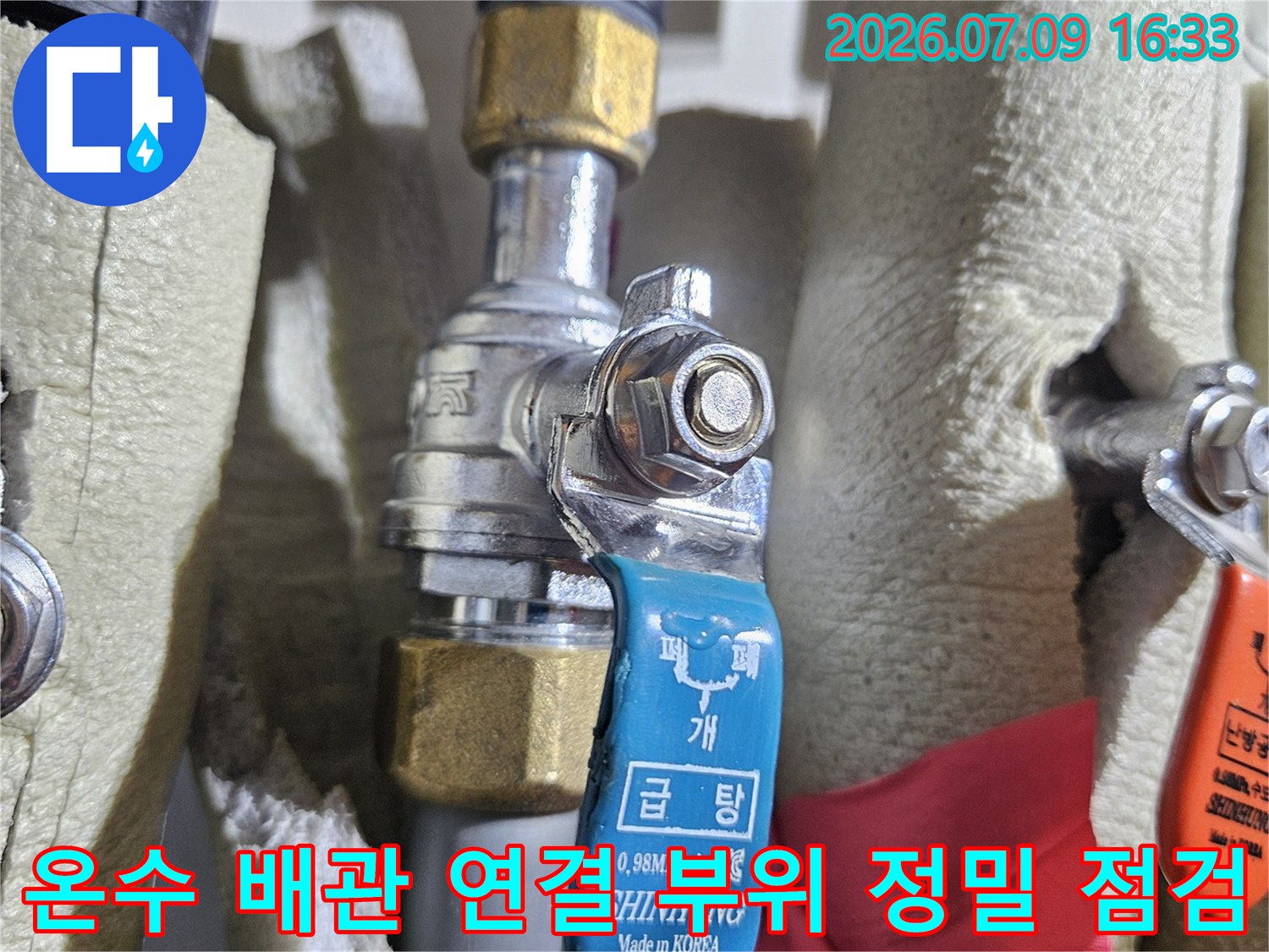 온수용 파란색 밸브가 장착된 금속 배관의 상세 모습