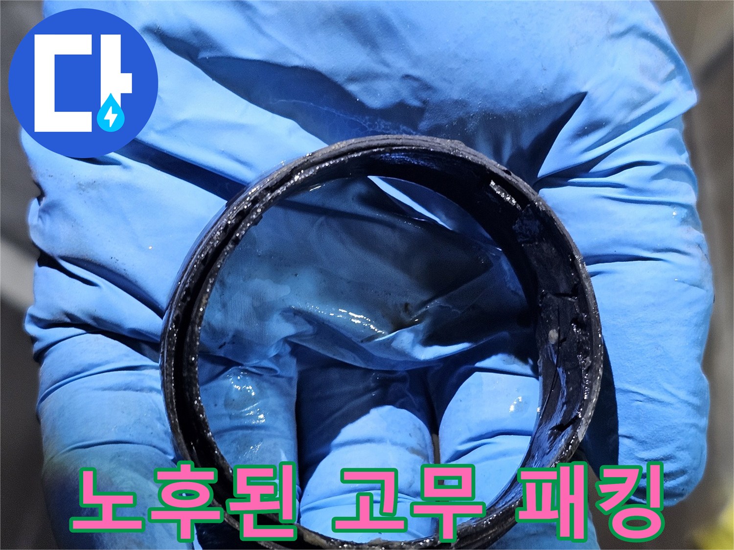 손에 들려 있는 마모되고 낡은 검은색 고무 패킹 부속