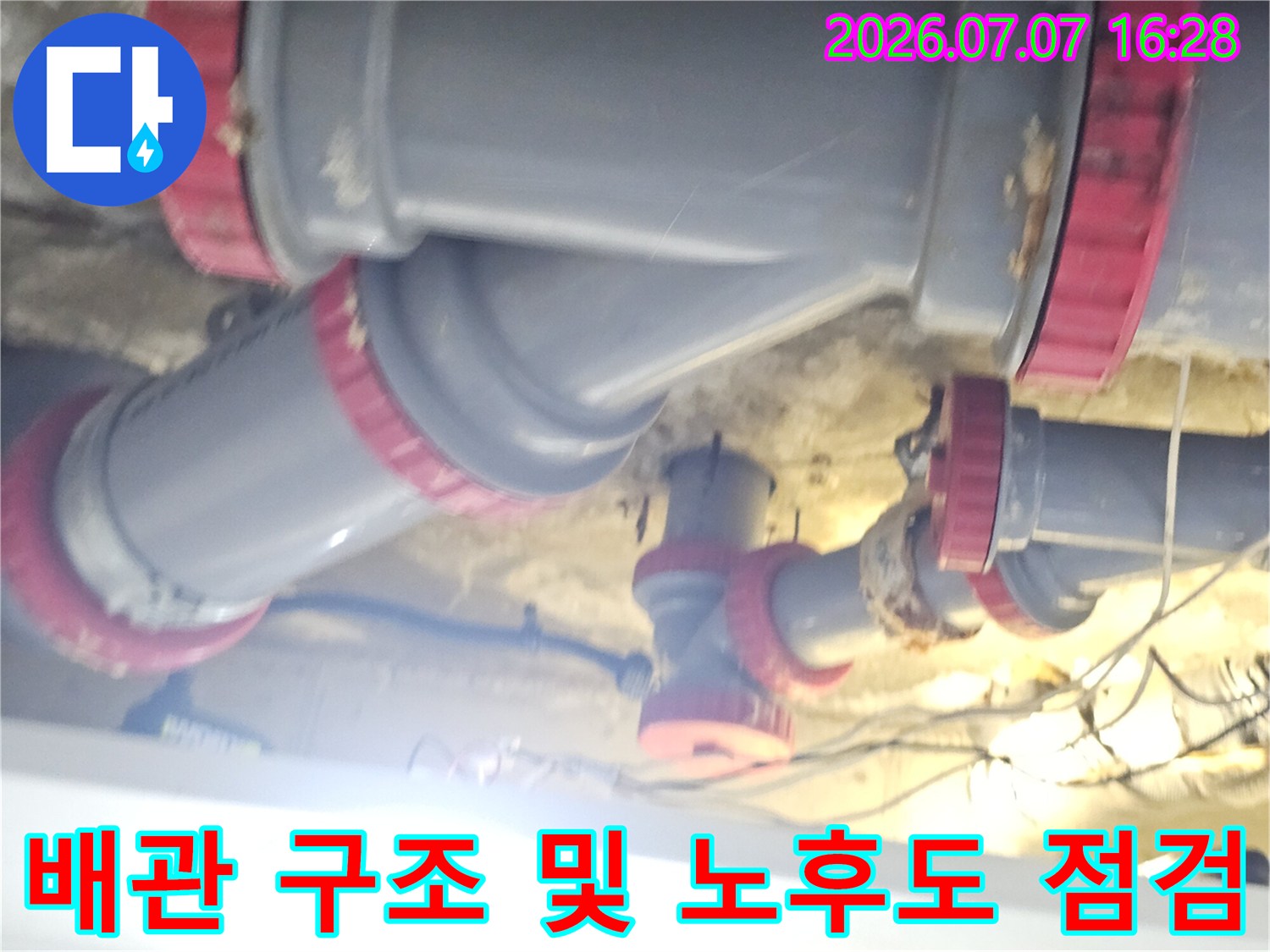 화장실 천장의 복잡한 배수 파이프망과 연결부위의 상태를 촬영함