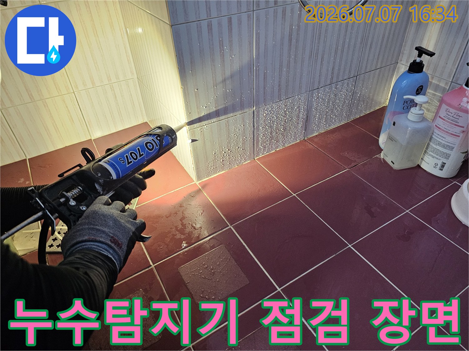 화장실 타일 위에서 누수 탐지기를 사용하여 배관 상태를 점검하는 모습