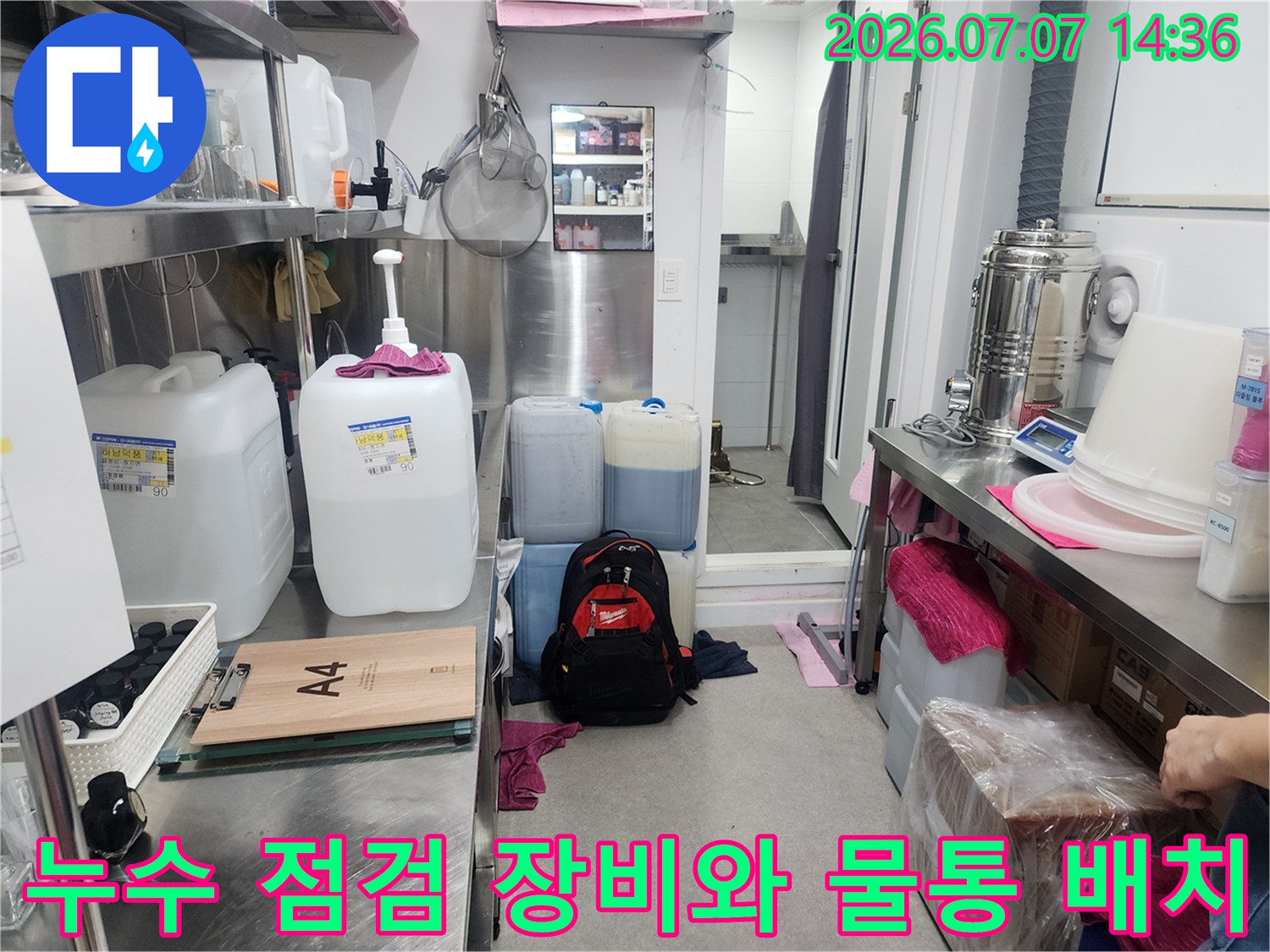 다양한 용량의 물통과 전문 도구가 준비된 화장실 내 작업 공간