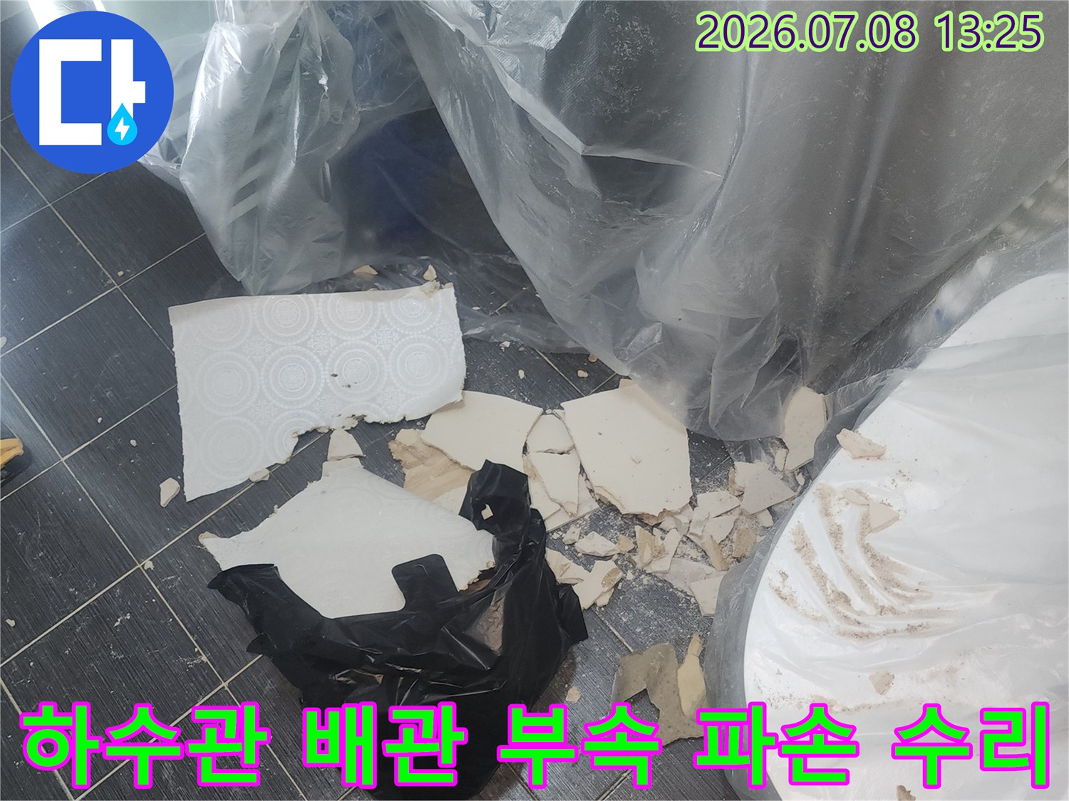 파손된 하수구 연결부 부품을 제거하고 새 제품으로 교체하는 모습