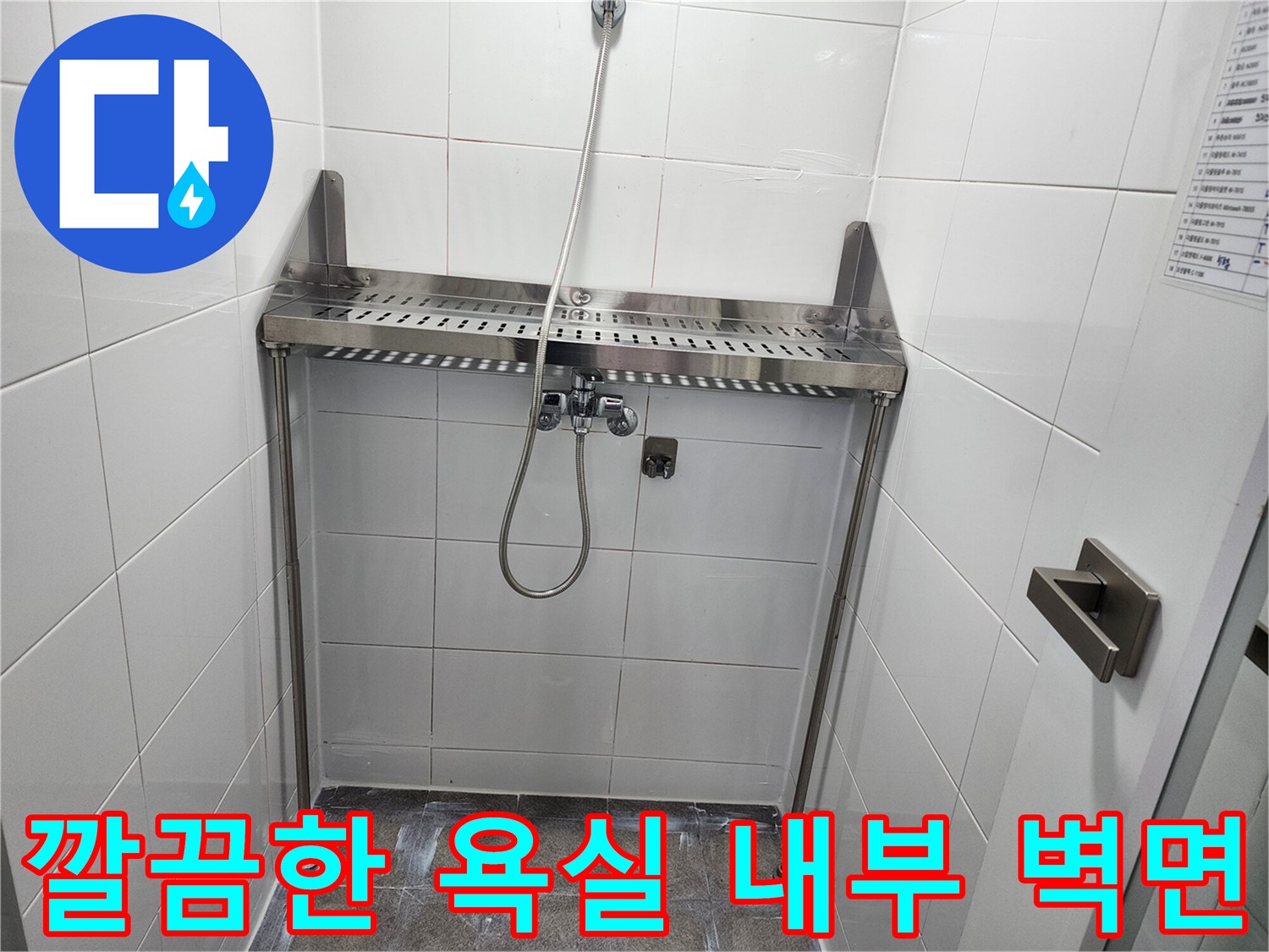샤워기 수전과 스테인리스 선반이 설치된 욕실 벽면