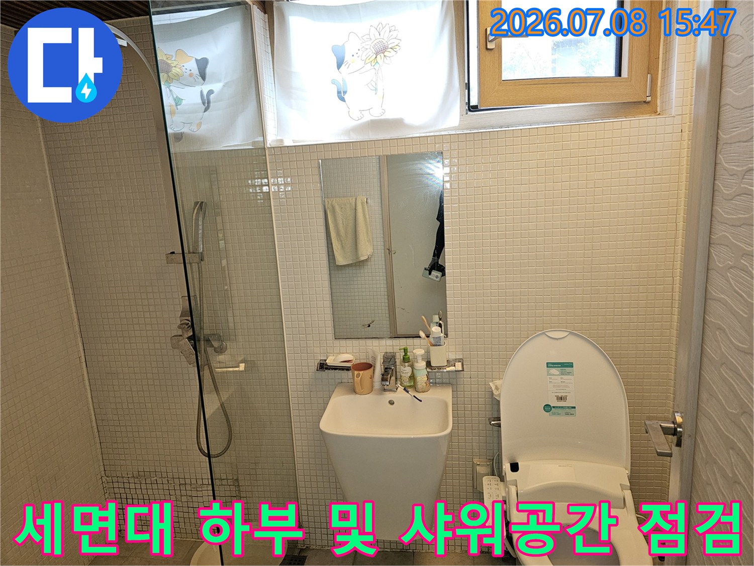 욕실 내부 세면대와 배관이 위치한 실내 모습