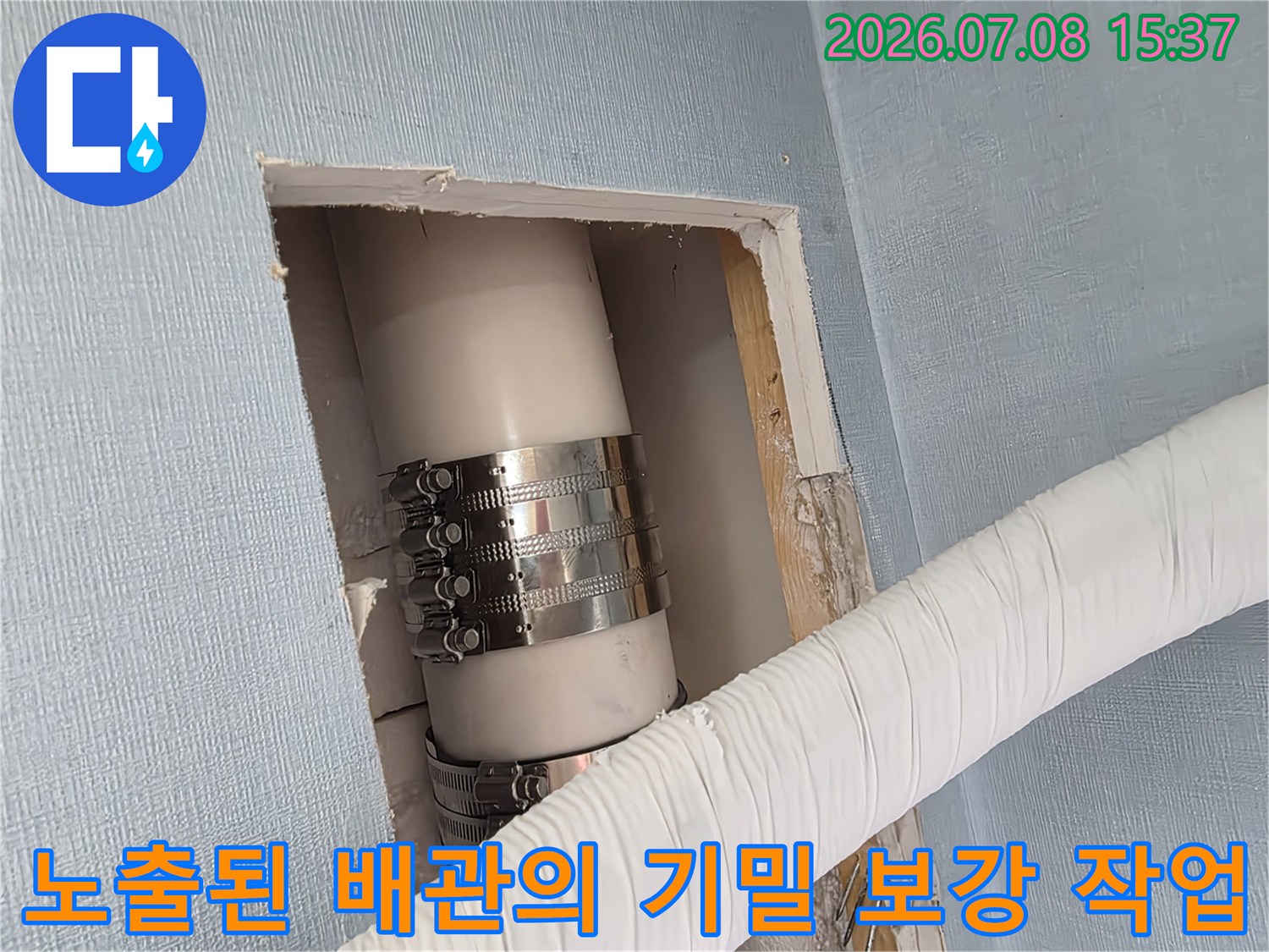 벽을 뚫고 확인한 에어컨 배수 호스와 금속 클램프 고정 부위