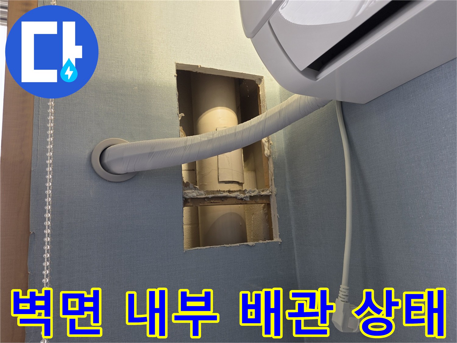 절개된 벽면 사이로-노출된 에어컨 배수 배관의 모습