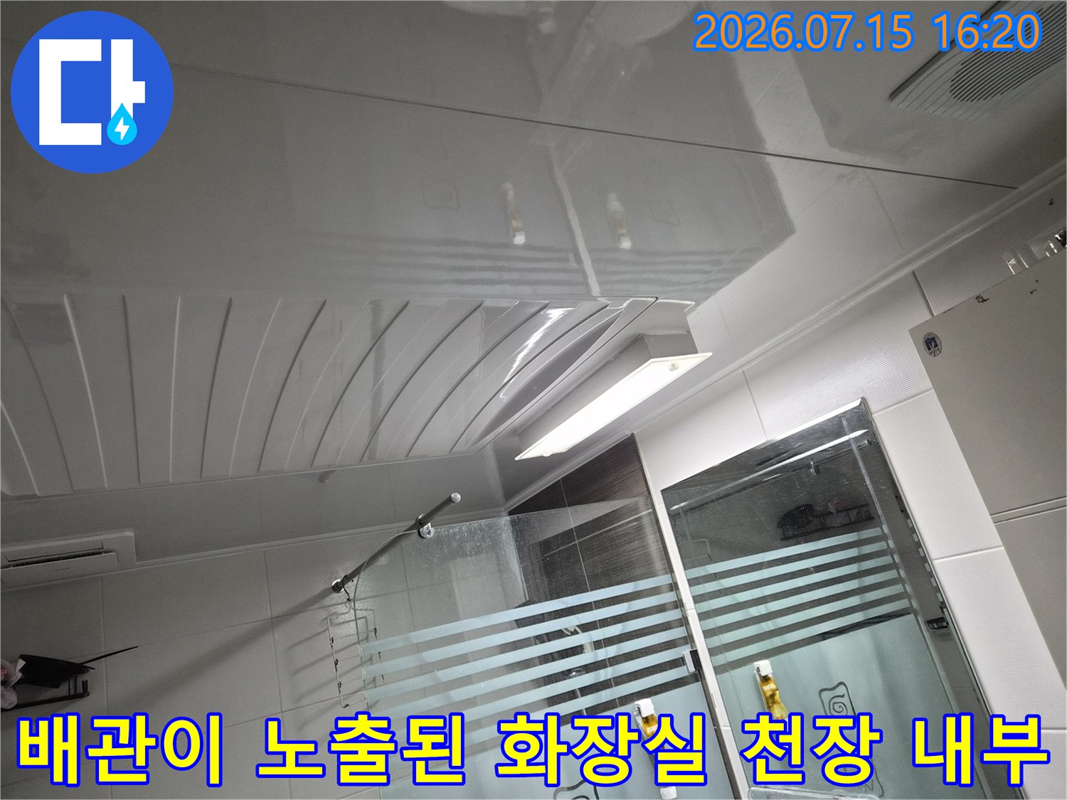 천장 내부에 설치된 환풍기와 배관 시스템을 점검하는 장면