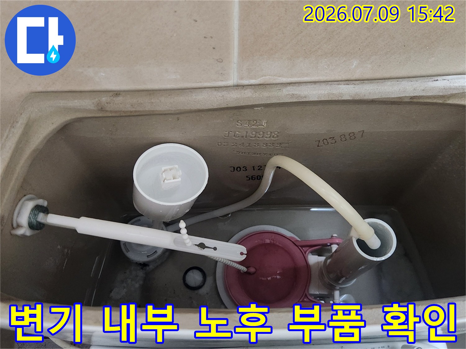 변기 물통 내부에 위치한 여러 기능성 부속들의 상태를 점검하는 모습