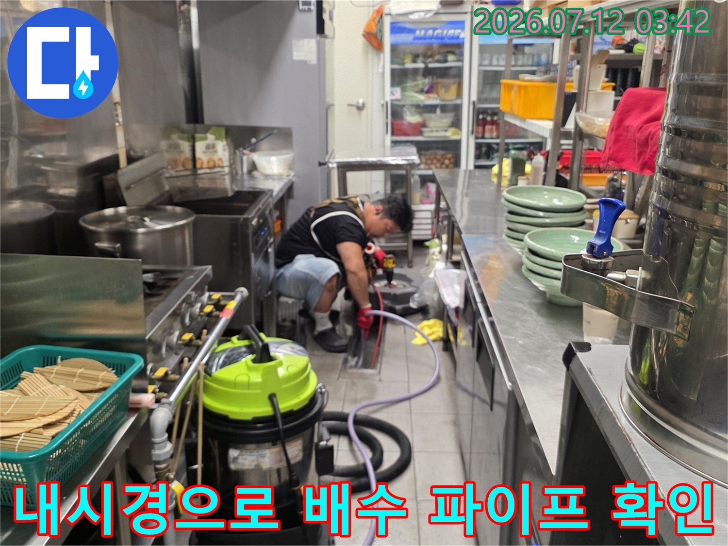 내시경 장비를 이용해 식당 바닥 하부의 배관 내부를 살피는 기술자