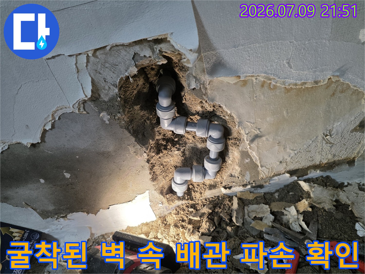 벽면을 뜯어내고 노출시킨 수도 배관의 연결부와 손상 부위