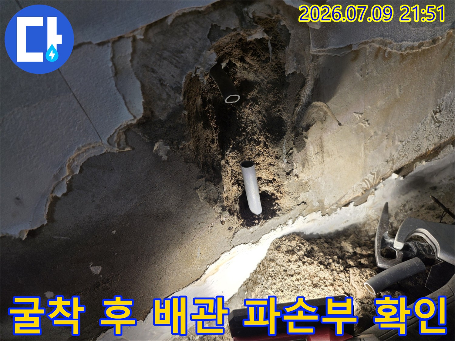 벽면을 파헤친 뒤 드러난 하얀색 배관과 주변의 거친 표면 상태