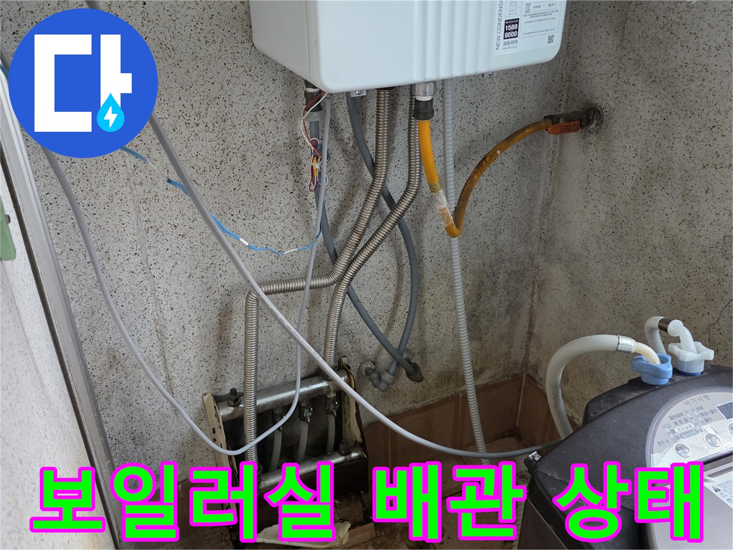 보일러 하단 배관-다양한 호스가 연결된 벽면의 배관 모습