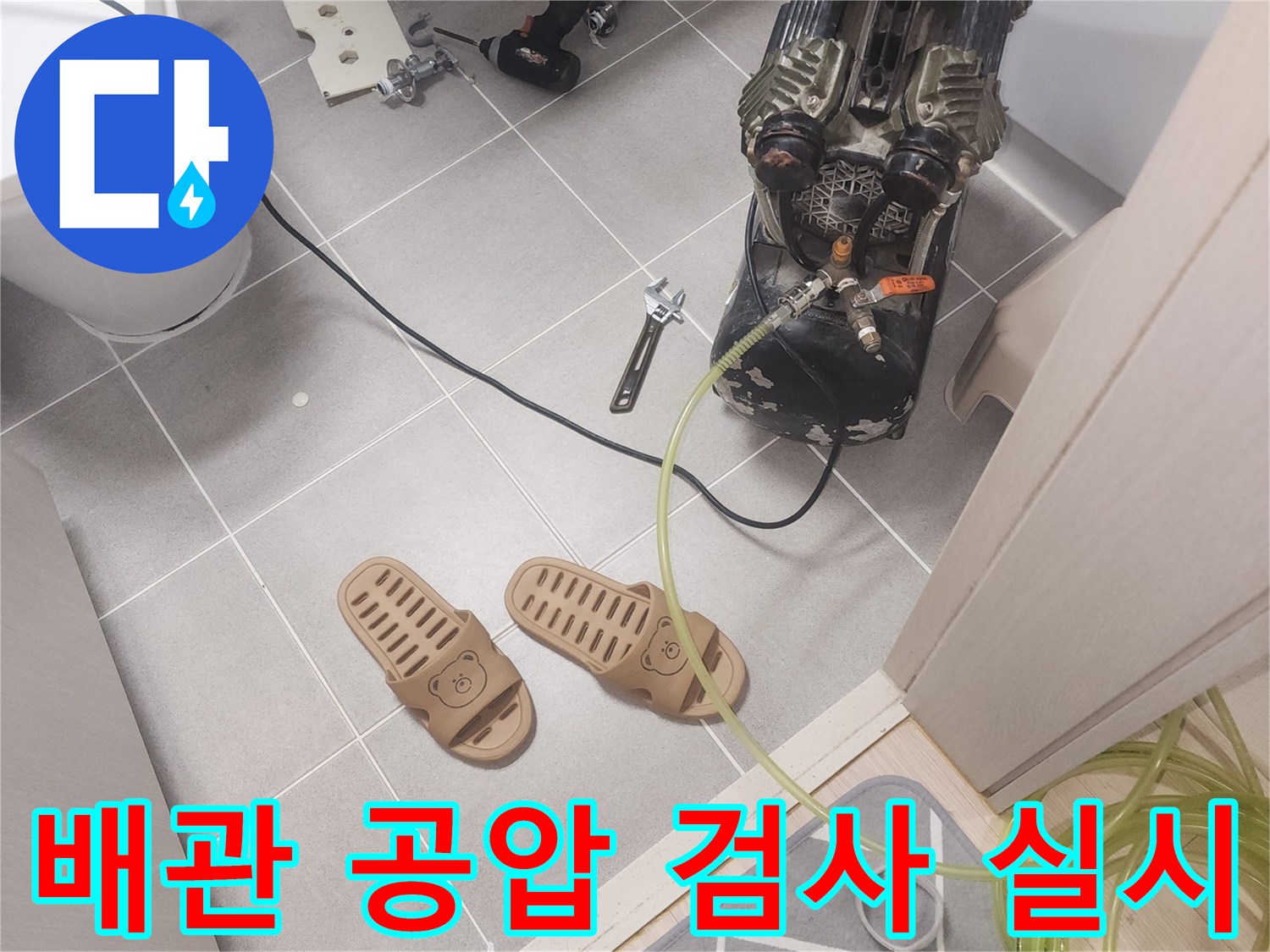 바닥에 설치된 배관 부속과 연결된 공압 호스 세트