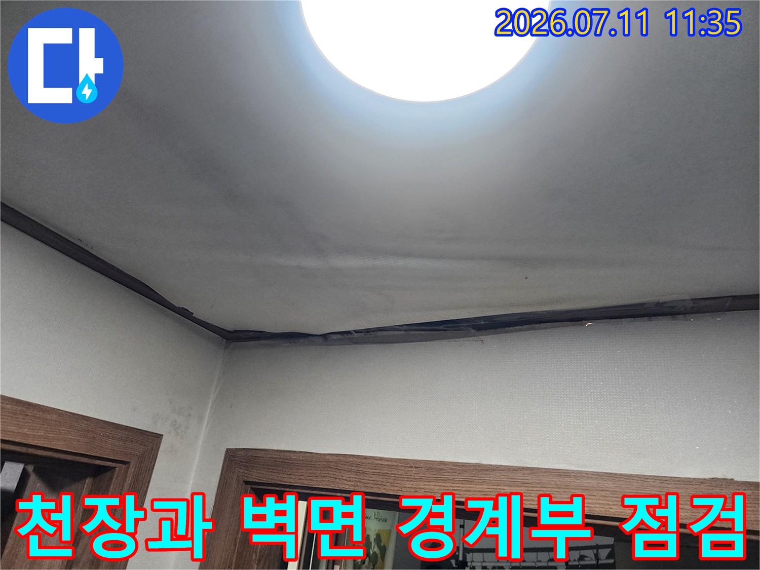 벽체와 천장의 접합 부위에 남은 누수 얼룩을 촬영한 사진