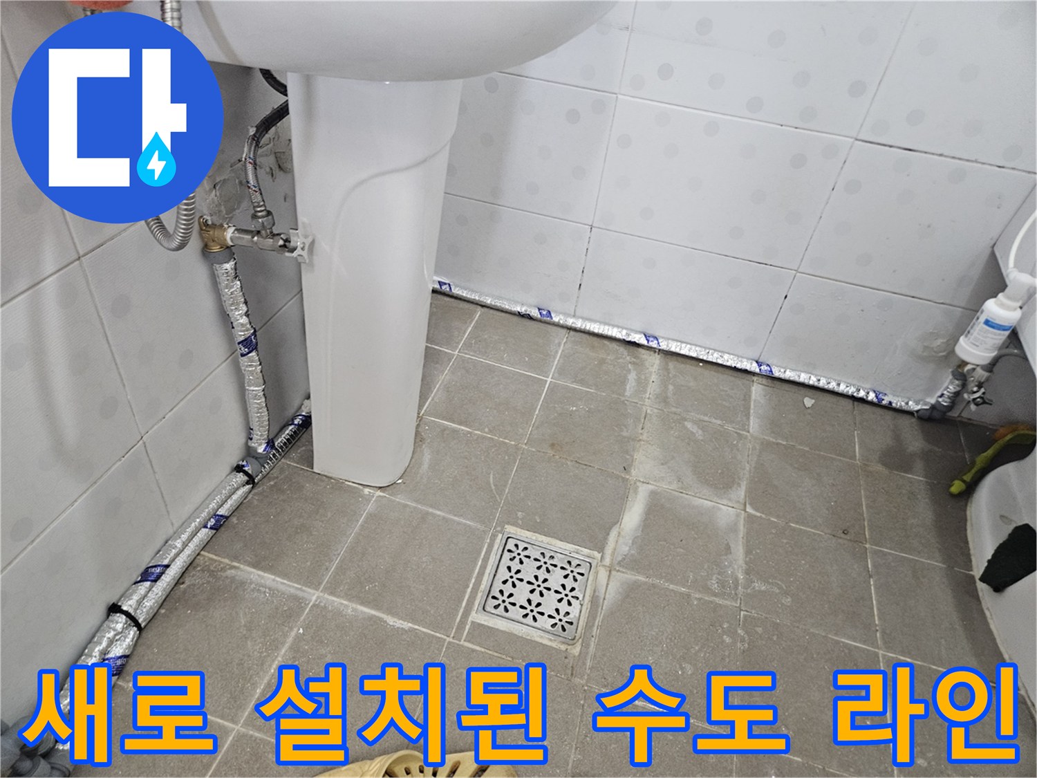 세면대 아래쪽으로 은박 보온재가 입혀진 새 직수 배관이 지나갑니다.