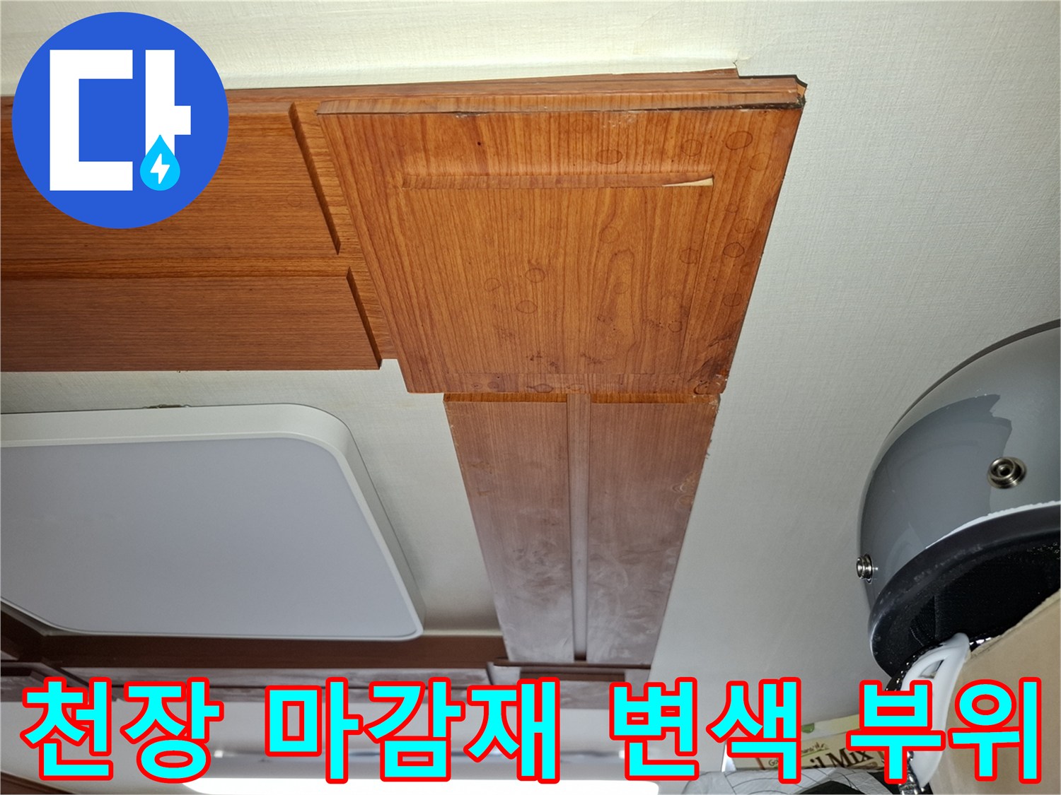 습기로 인해 어둡게 얼룩진 천장 목재 마감재의 모습