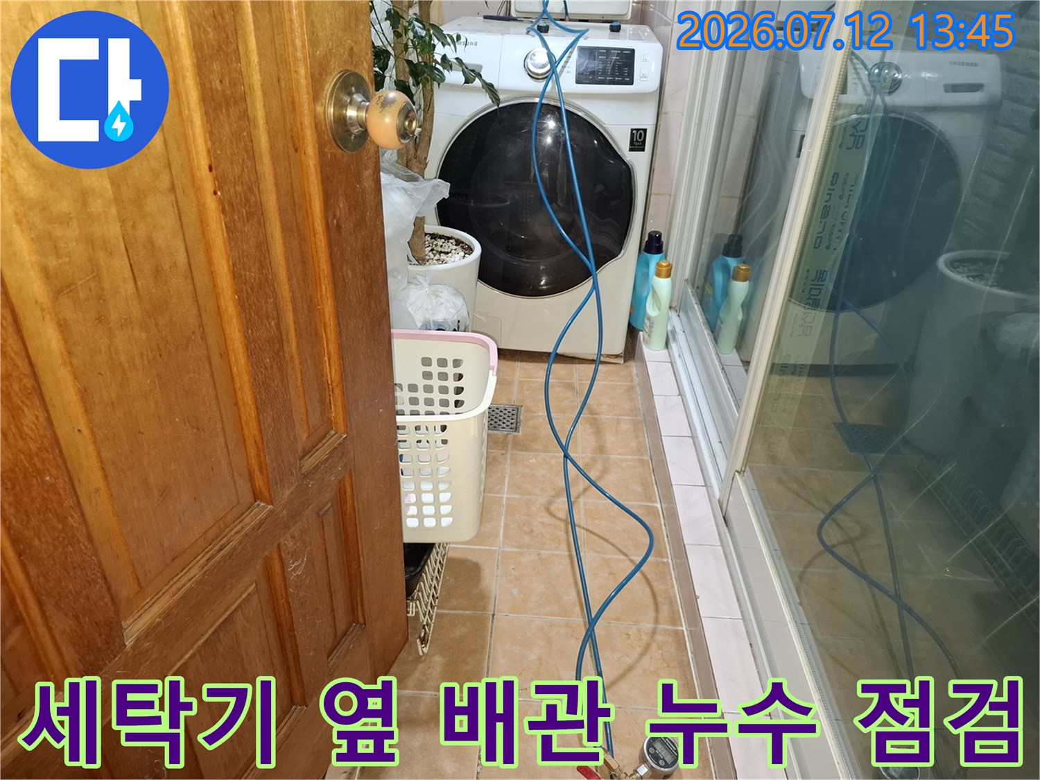 파란색 장비 호스가 연결된 세탁실 환경에서 진행되는 정밀 배관 탐지 과정