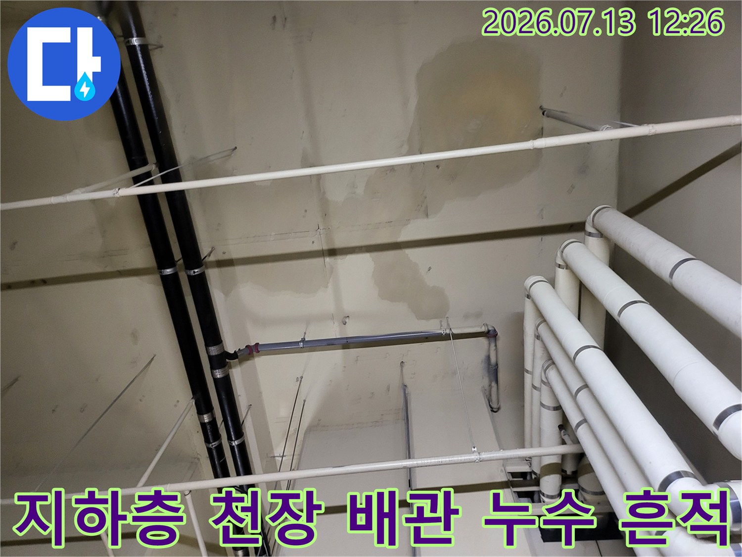 배관 주변에 발생한 노란색 누수 얼룩과 수평/수직 배관이 설치된 지하층 천장 모습