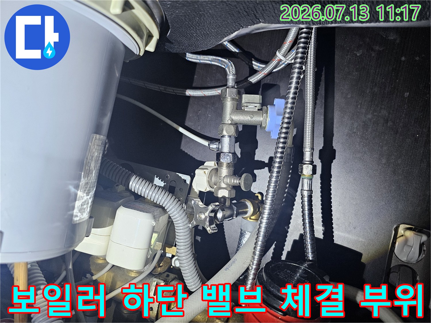 금속제 파이프와 파란색 밸브가 복잡하게 구성된 보일러-하부배관