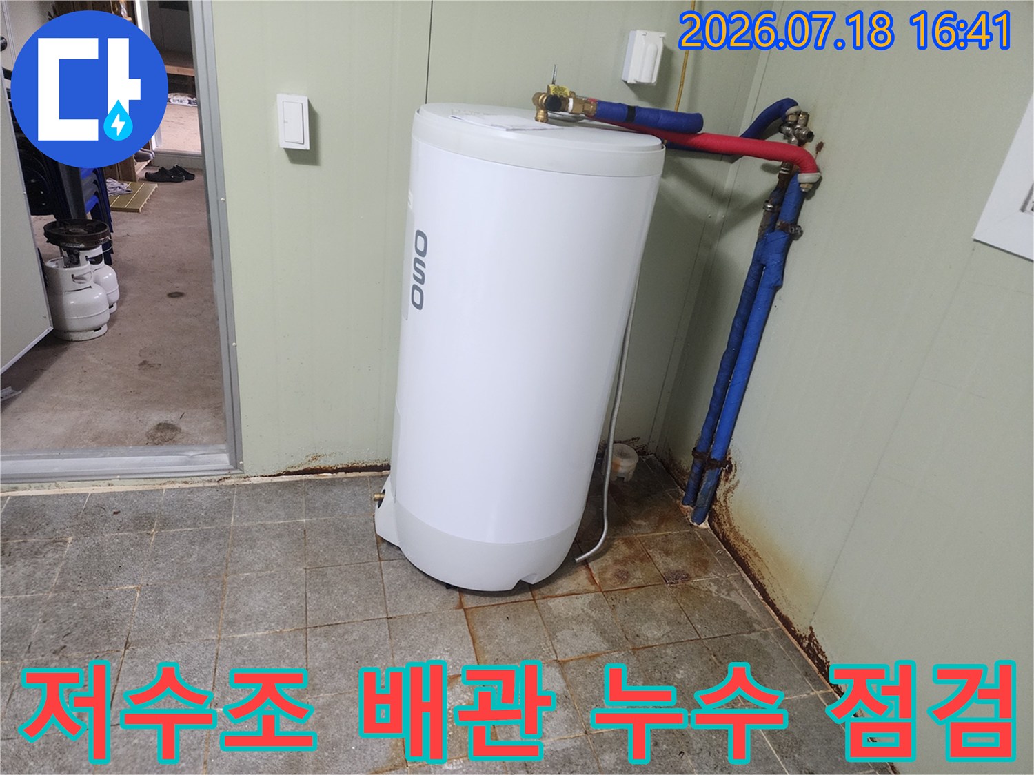 흰색 저수조와 파란색 및 빨간색 배관 연결부위