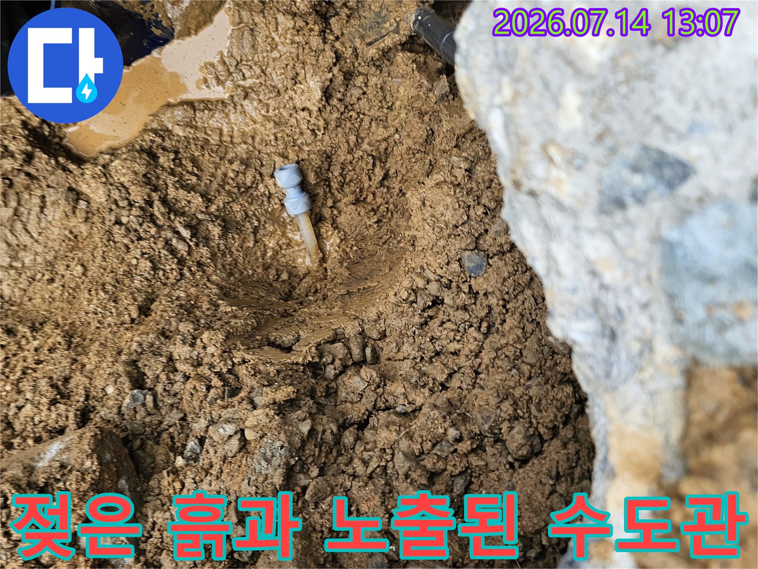 물에 젖어 변색된 토양과 노출된 배관 부위
