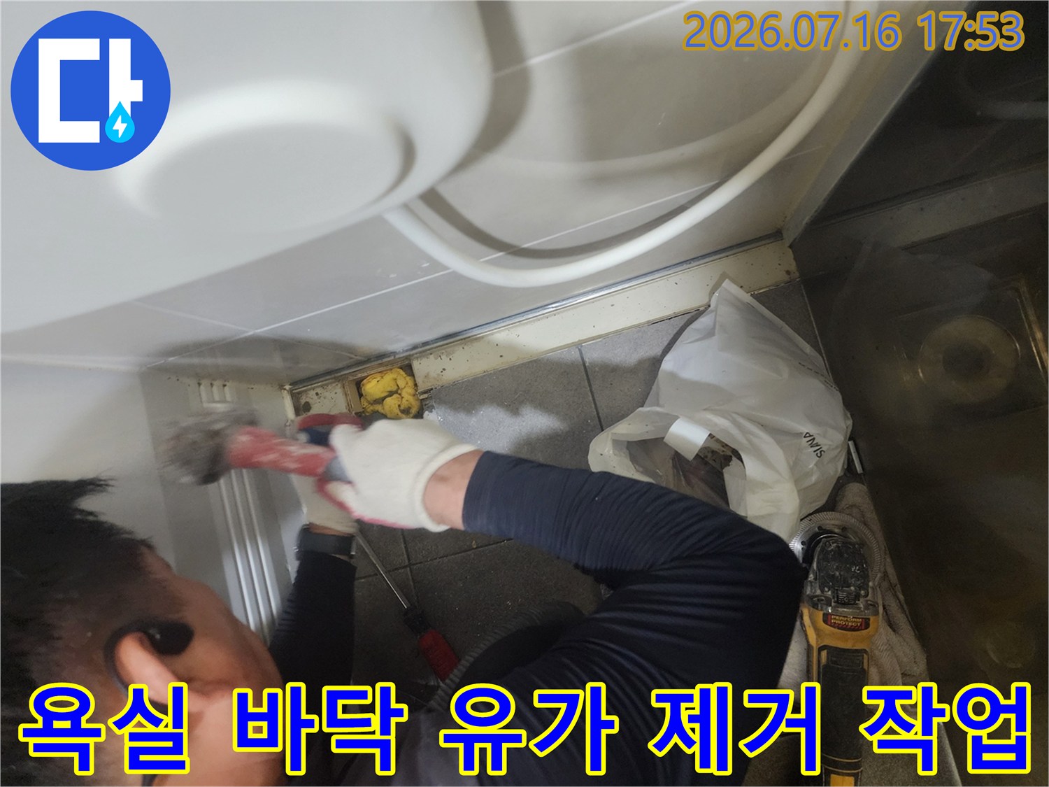 작업자가 장비를 사용하여 욕실 트렌치 유가 부위를 제거하는 모습