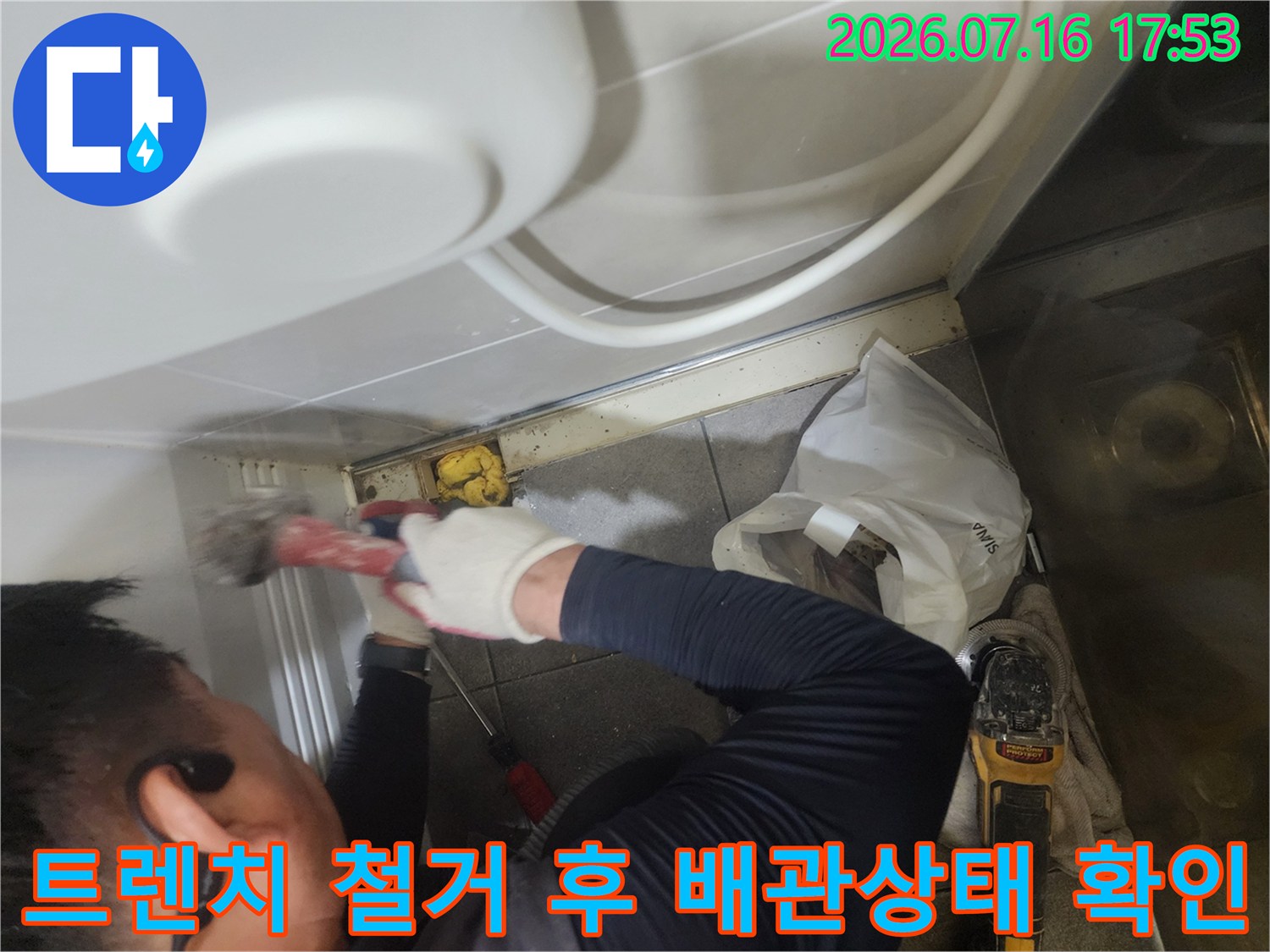 전문가가 장비를 사용하여 욕실 트렌치 유가를 제거하는 시공 장면
