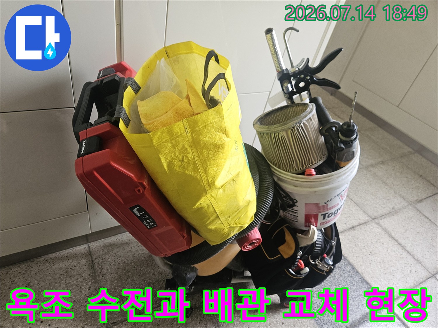 배관 점검용 공구와 버킷이 배치된 욕조 주변의 작업 공간