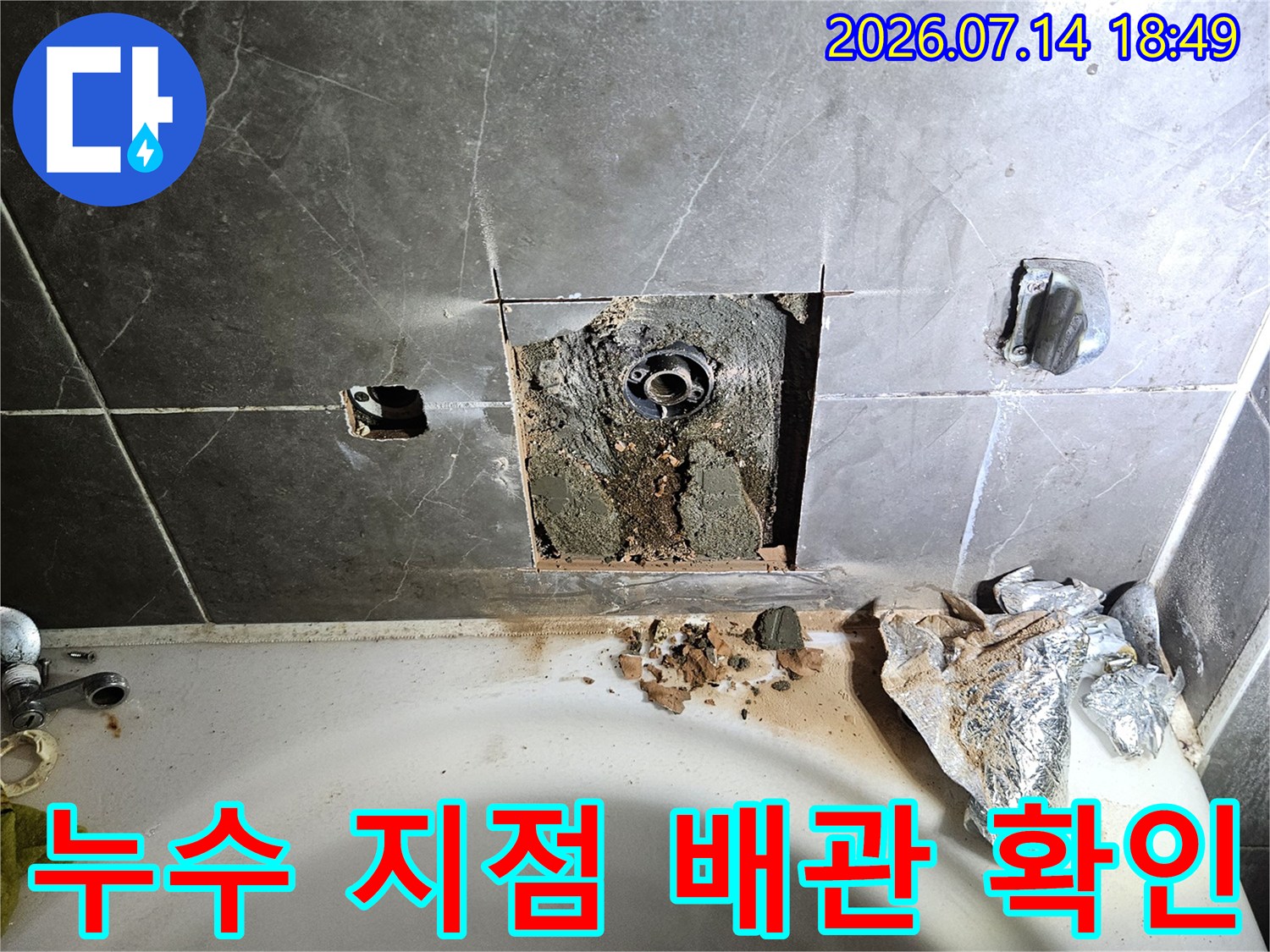 욕조 수전 위치 타일 파쇄 후 노출된 내부 배관 점검을 위한 공사 현장